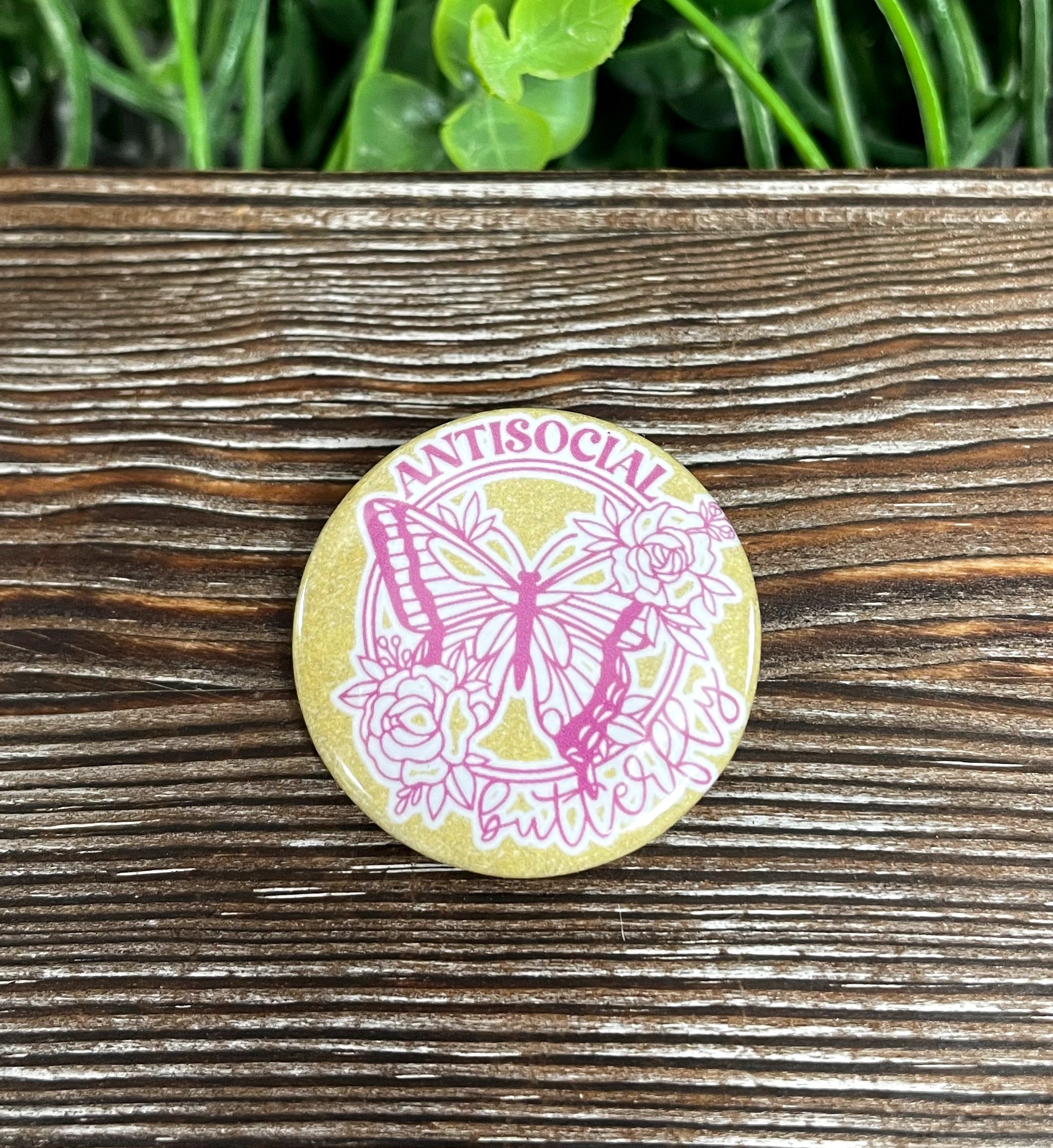 Antisocial Butterfly graphic art button with gold glitter, measuring 1.25 inches, showcasing a vibrant design.