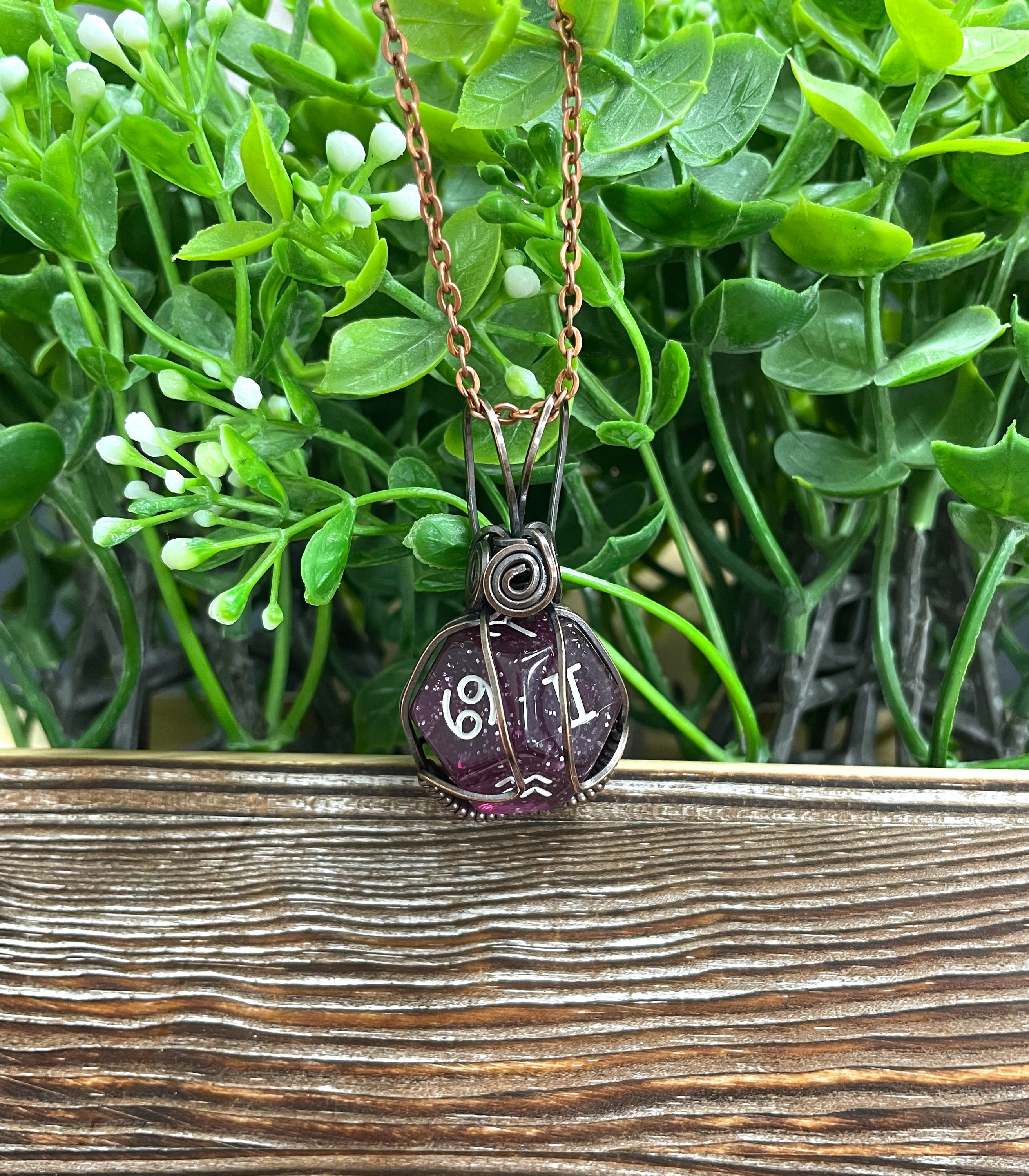 Astrological D12 dice pendant wrapped in oxidized copper wire on a suede leather cord, showcasing unique colors and symbols.