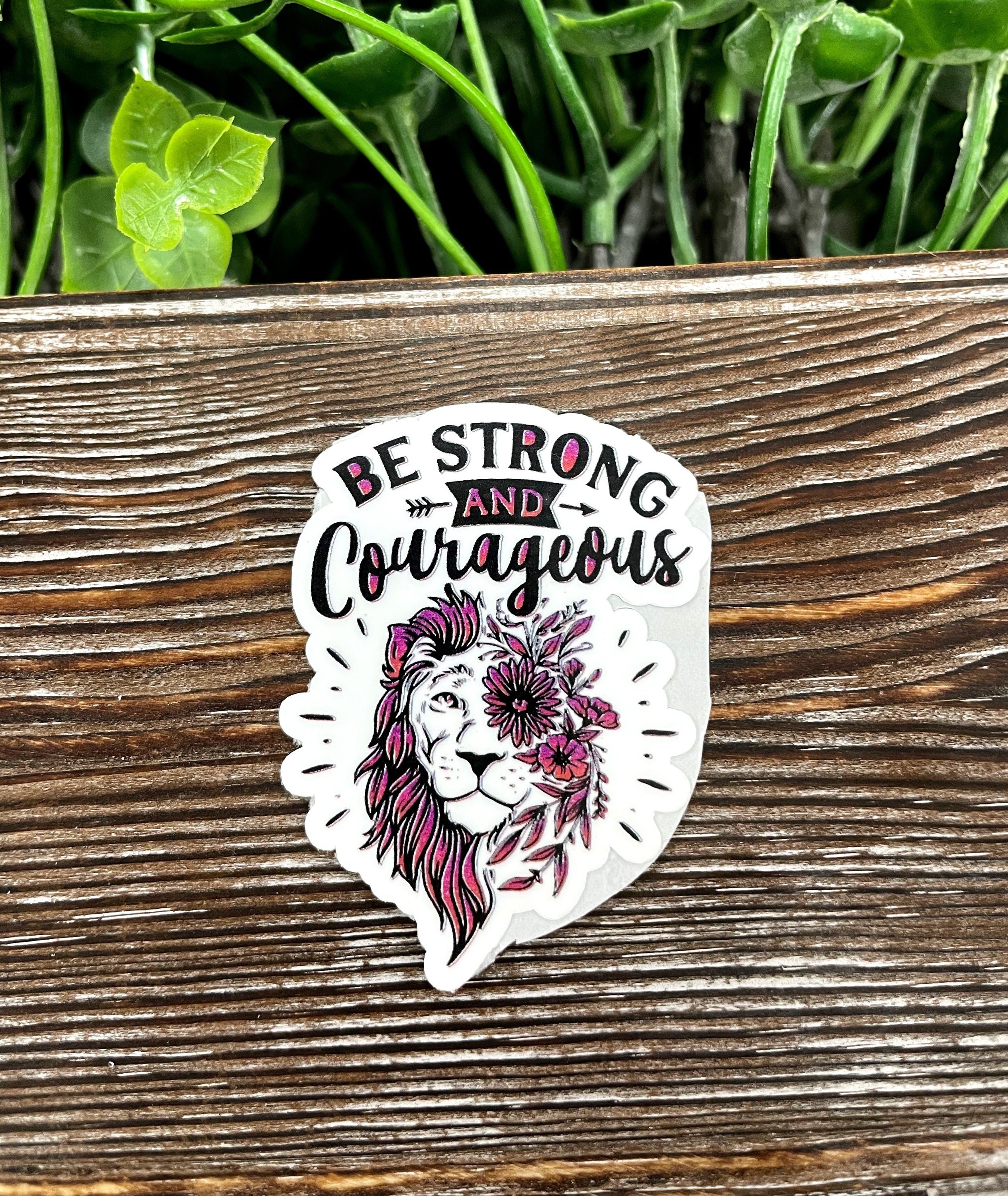 Be Strong and Courageous Die Cut Sticker on a smooth surface, showcasing vibrant colors and inspirational text.
