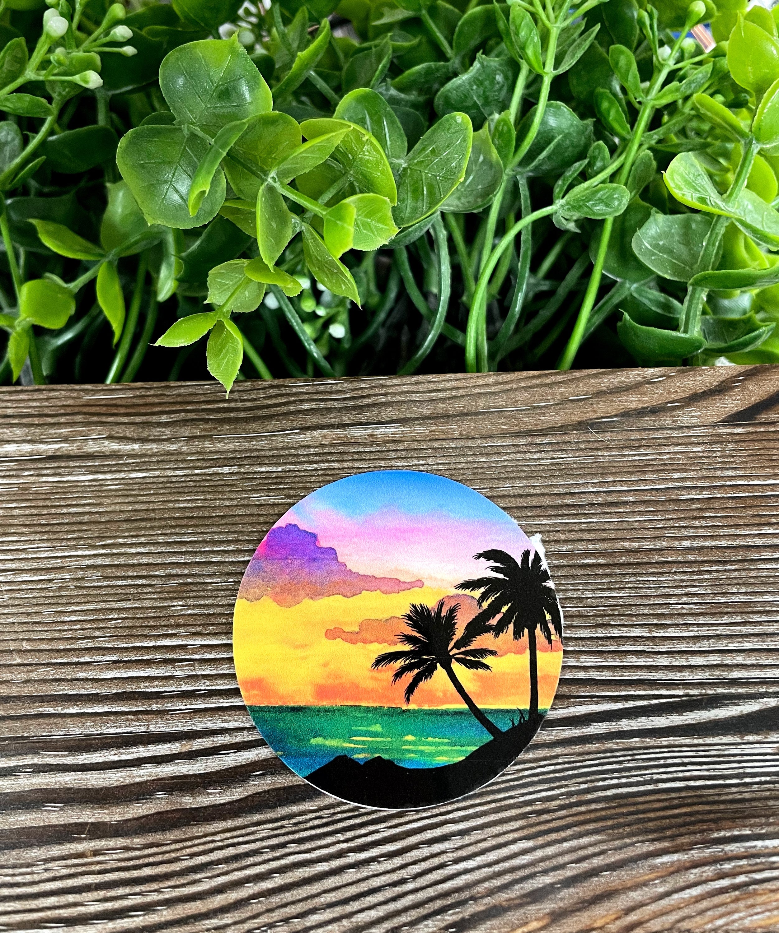 A vibrant Beach Sunset Watercolor die cut vinyl sticker featuring a colorful sunset over the ocean, perfect for personalizing items.