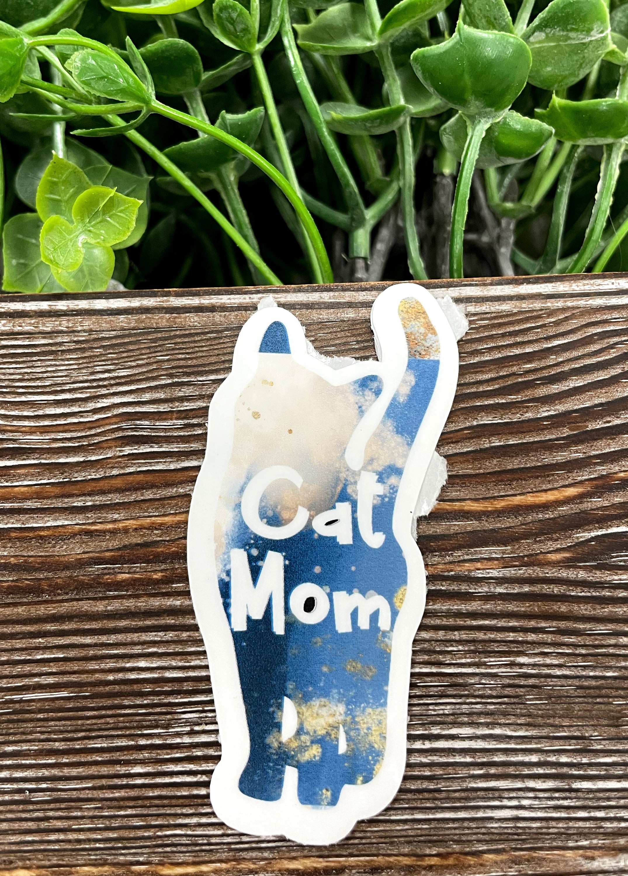 Blue and gold glitter die cut sticker featuring the text 'Cat Mom' with a stylish design, perfect for personalizing items.