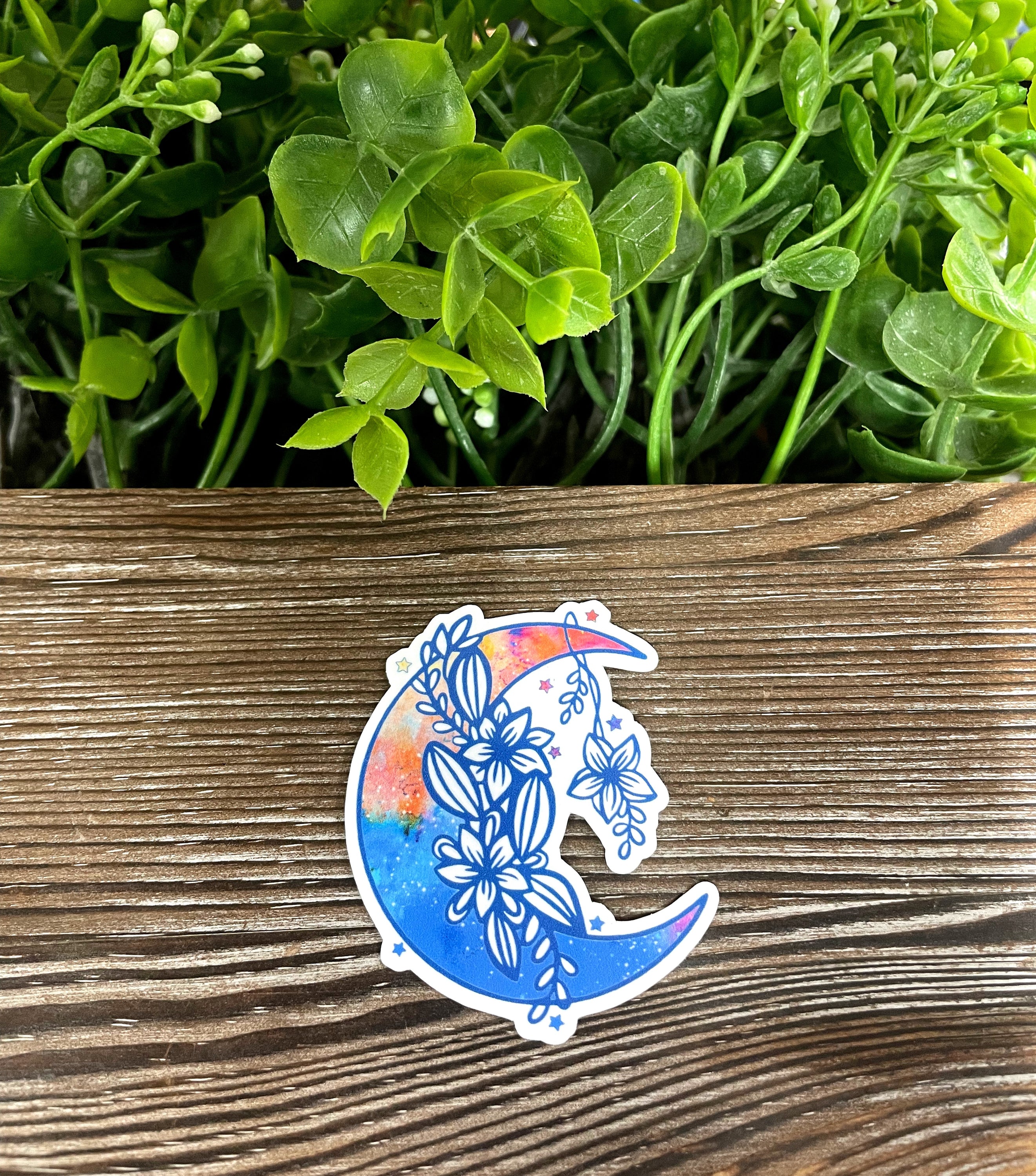Blue and orange crescent moon sticker on a smooth surface, showcasing vibrant colors and intricate design.
