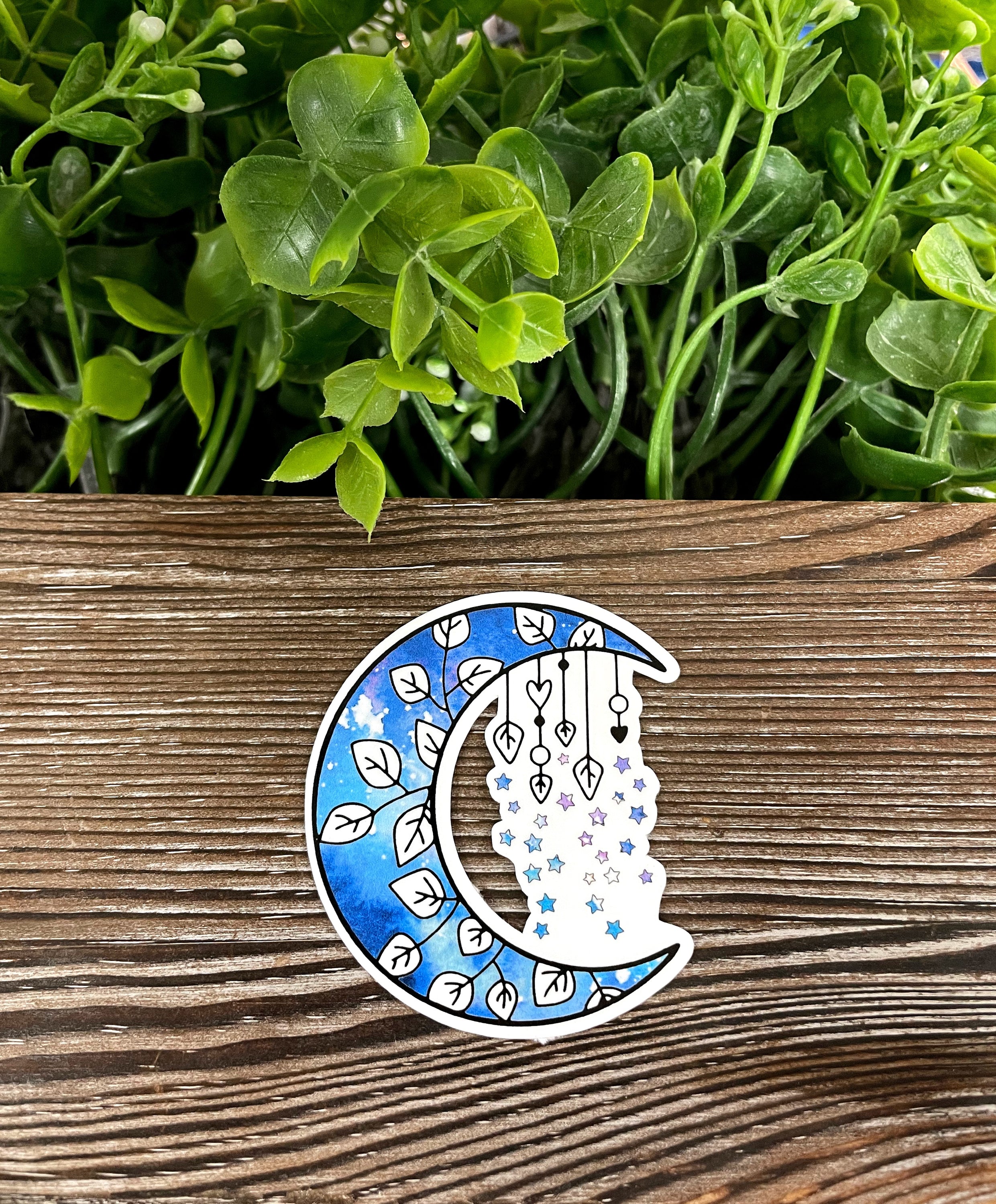 A vibrant blue crescent moon surrounded by stars sticker, showcasing intricate details and a whimsical design.