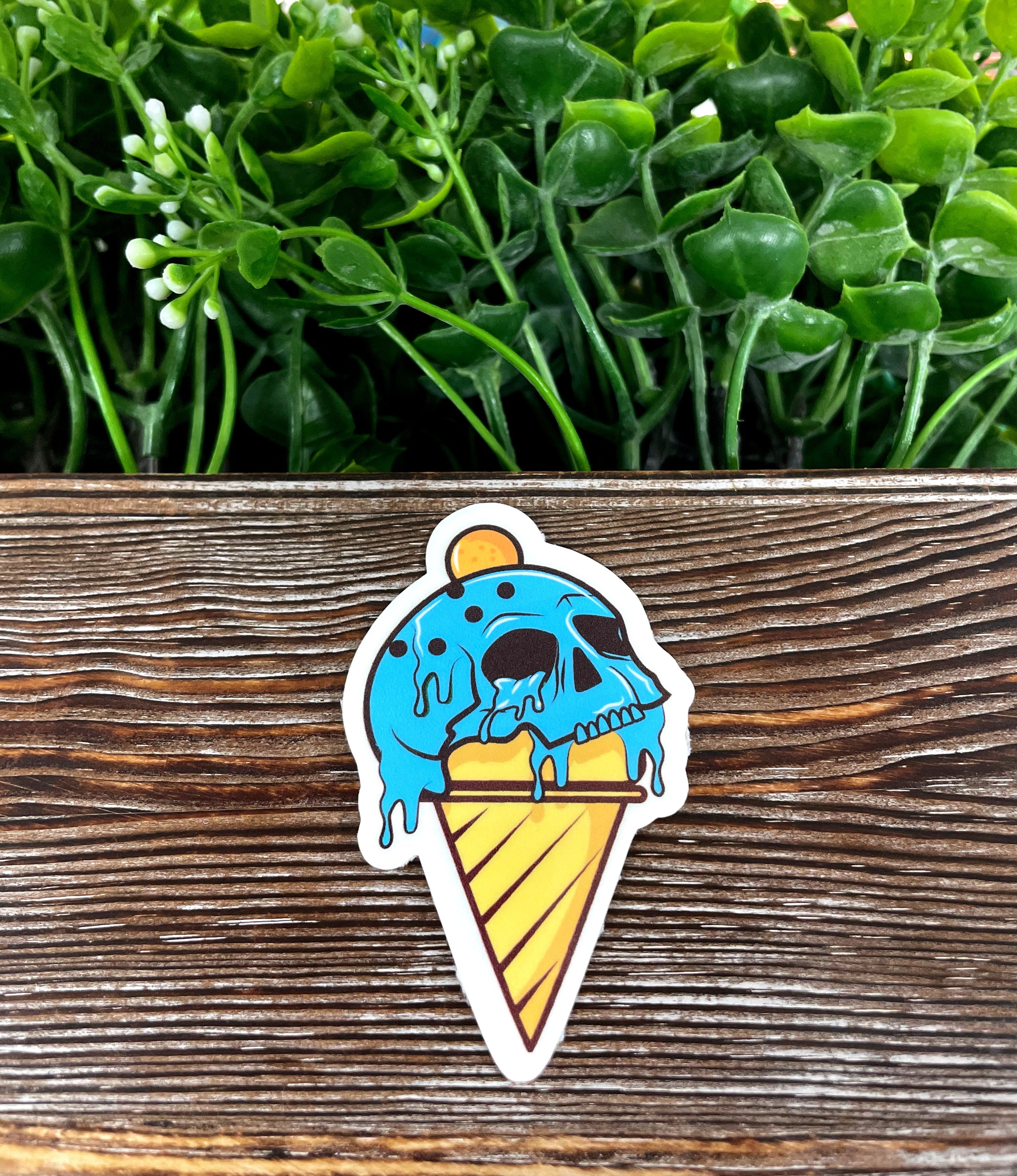 Blue Skull Ice Cream Cone die cut vinyl sticker on a smooth surface, showcasing vibrant colors and unique design.