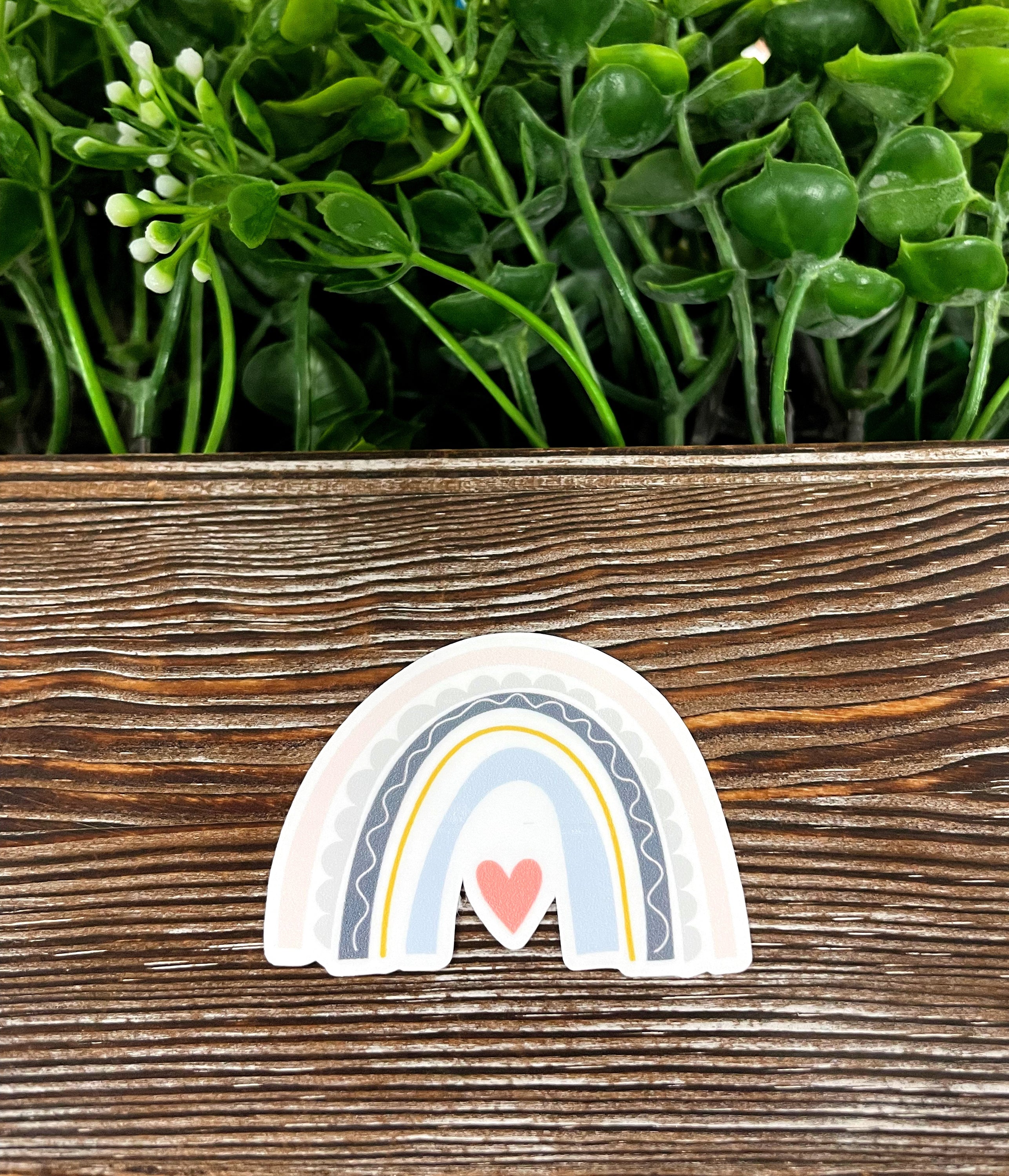 A colorful Bohemian Rainbow Heart die cut sticker on a smooth surface, showcasing vibrant colors and intricate design.
