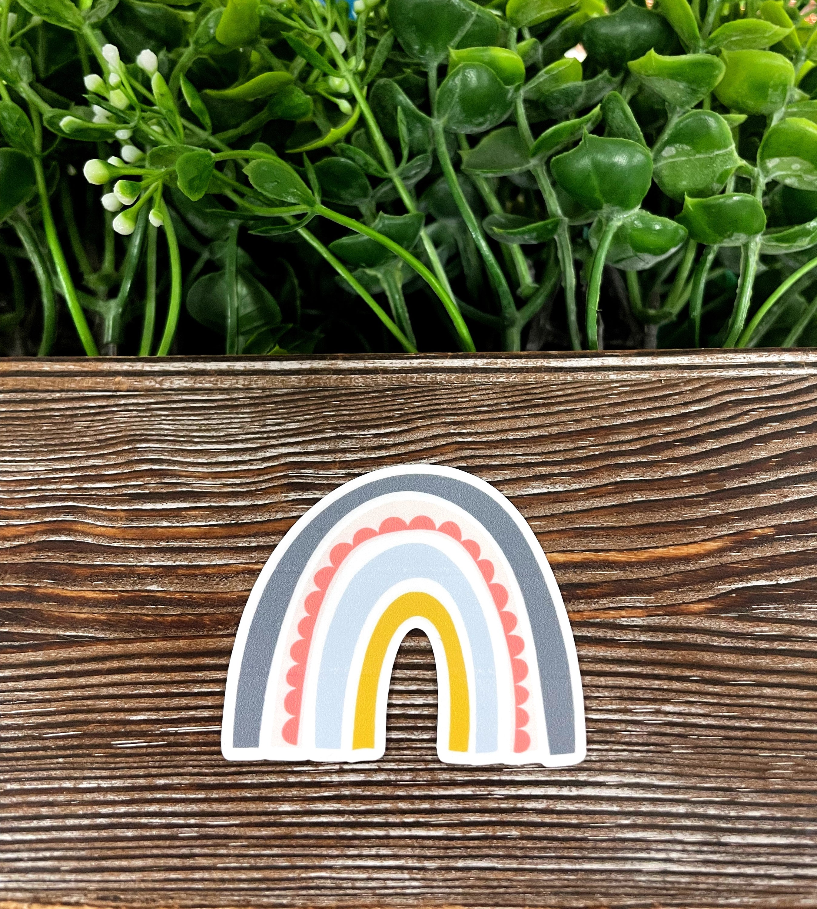 A colorful Bohemian Style Rainbow die cut sticker on a smooth surface, showcasing its vibrant design and quality finish.