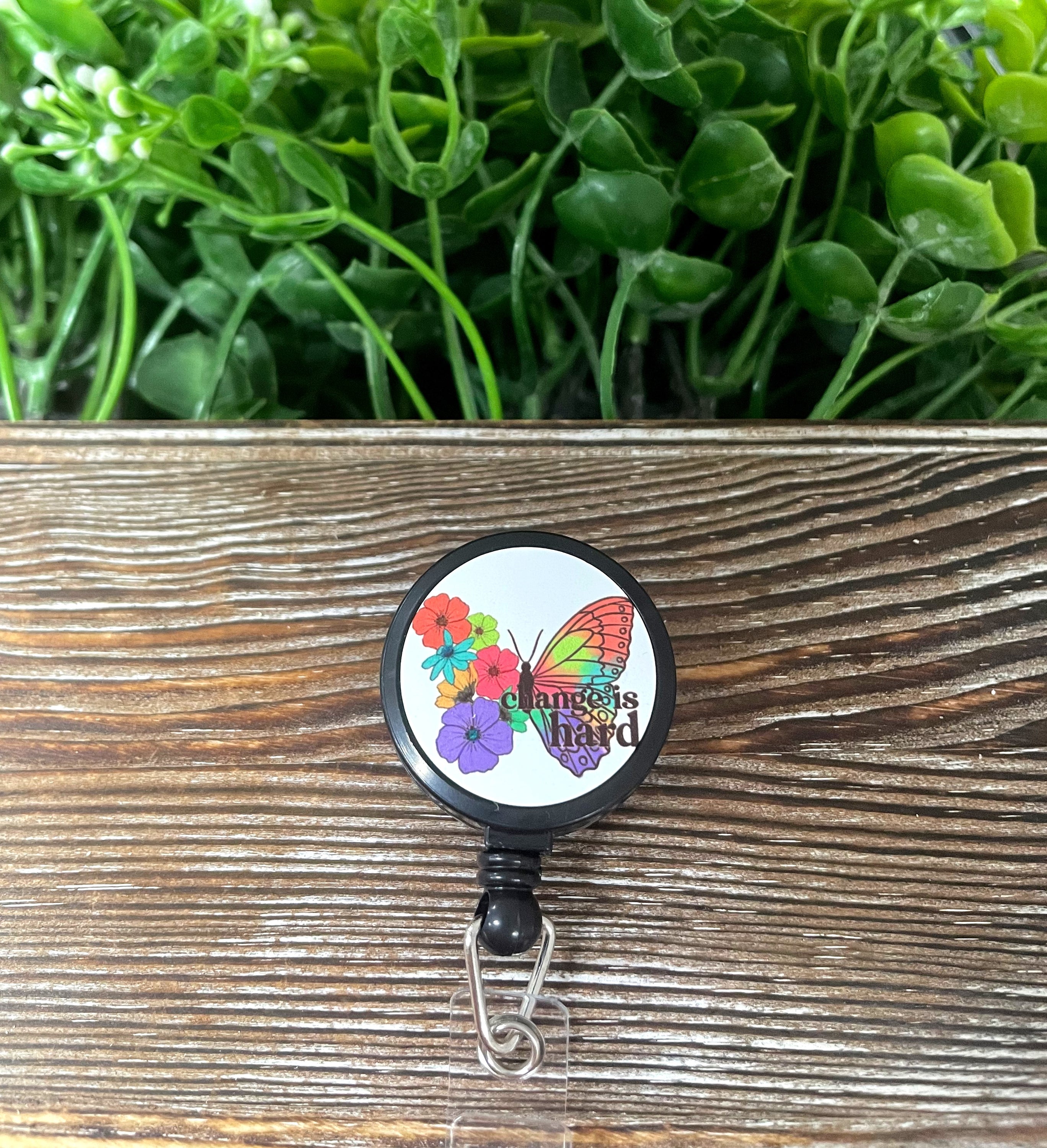 Change is Hard Butterfly retractable badge reel with colorful butterfly design on a metal blank, attached to a plastic reel.