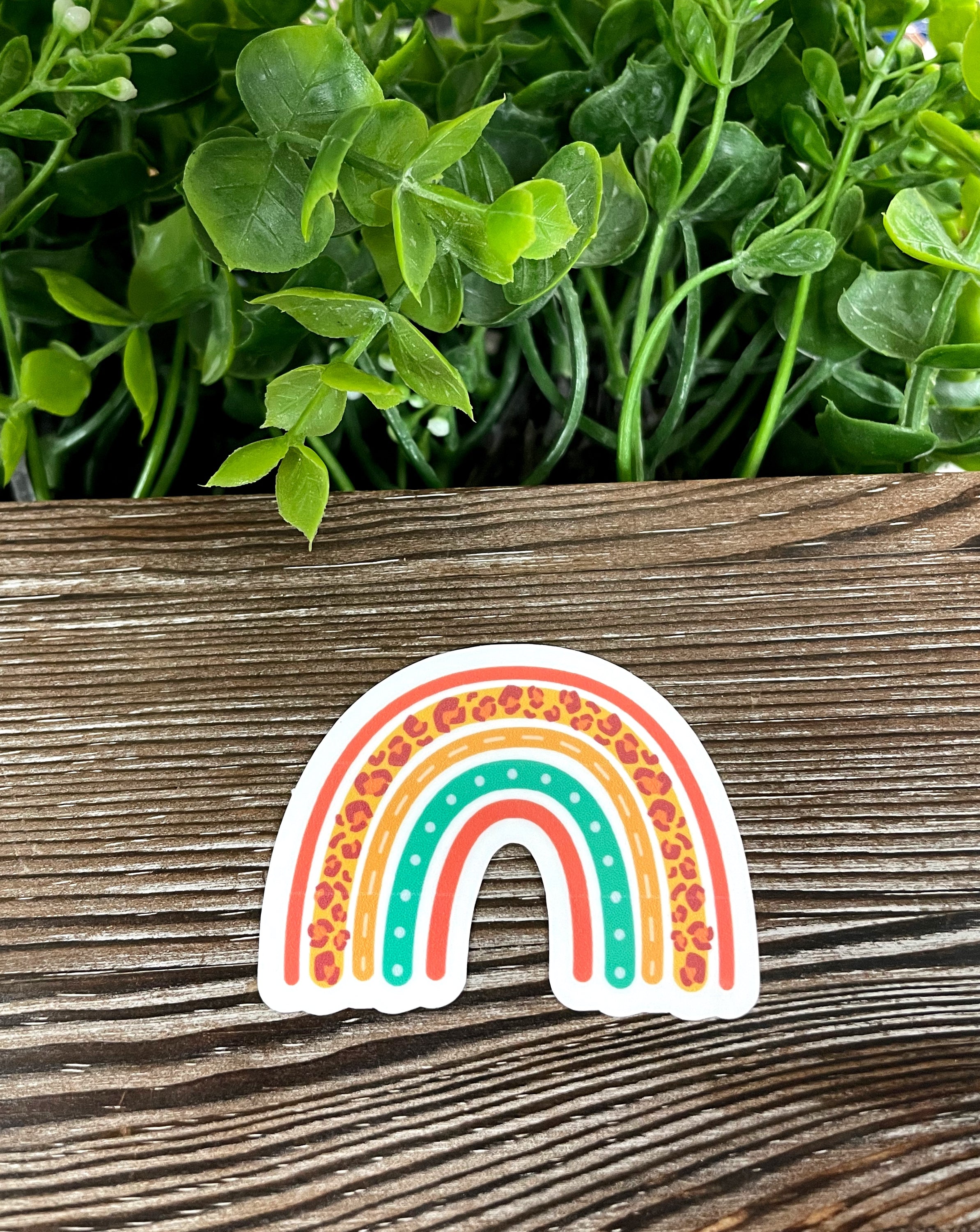 Cheetah Print Rainbow die cut vinyl sticker on a smooth surface, showcasing vibrant colors and unique design.