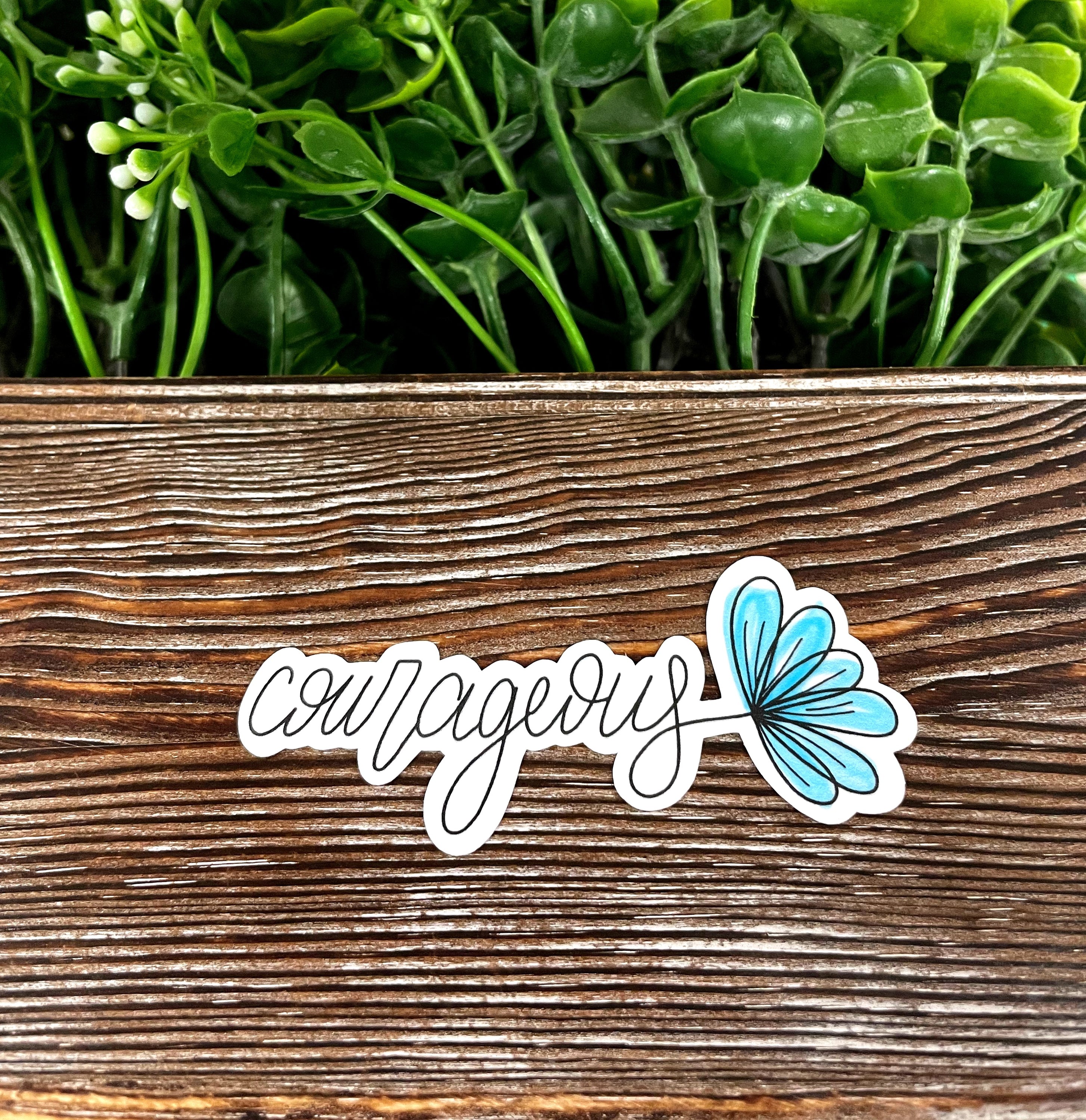Courageous Script Lettering die cut sticker on a smooth surface, showcasing vibrant colors and intricate design.