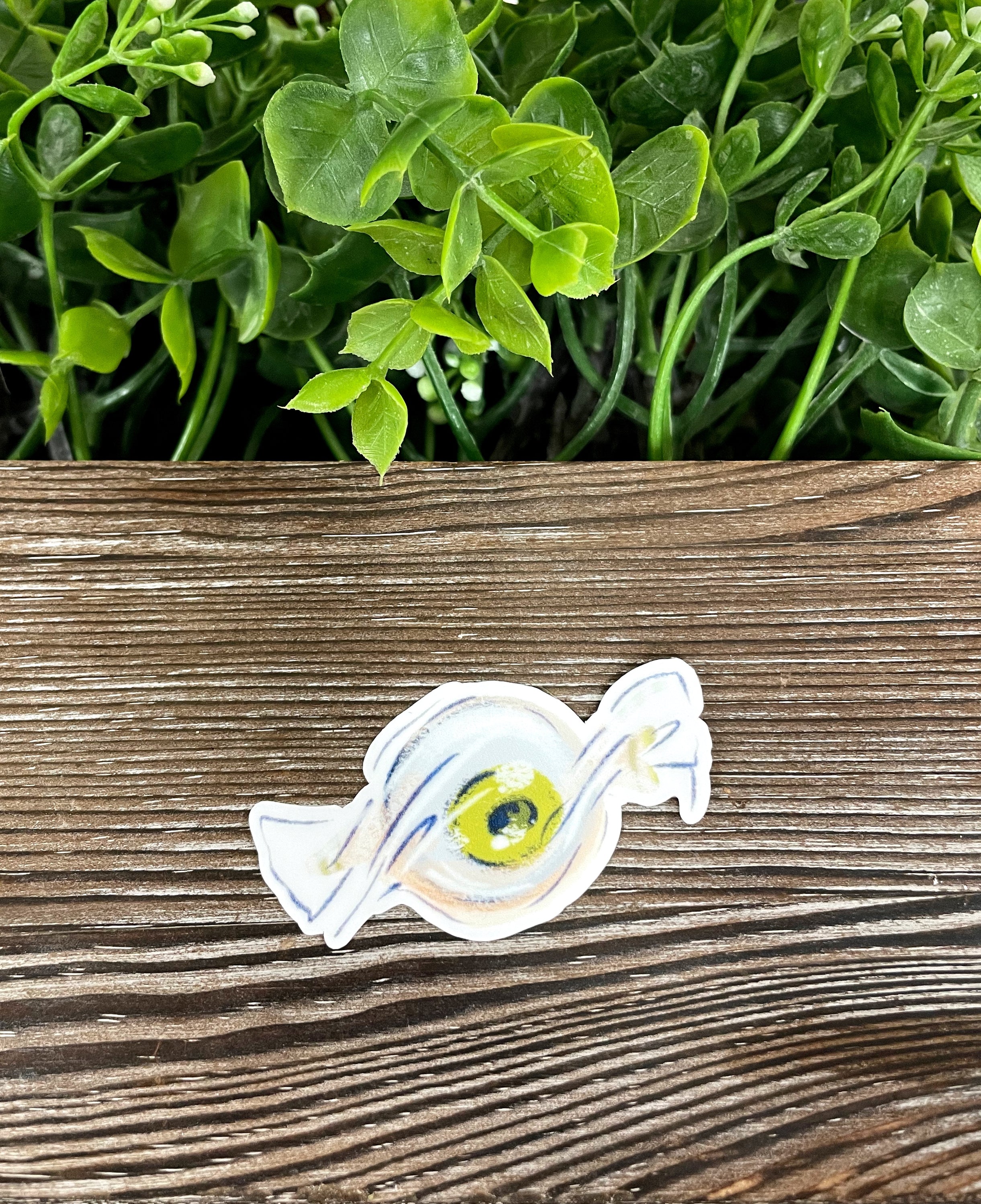 Colorful Eyeball Candy Wrapper die cut vinyl sticker on a smooth surface, showcasing its vibrant design and water-resistant laminate.
