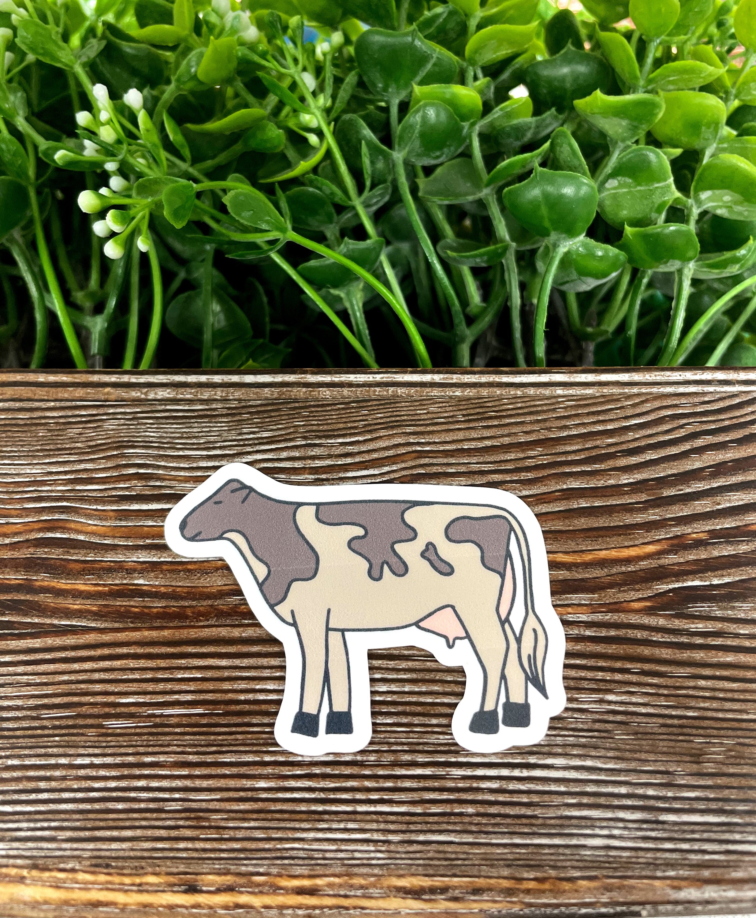 A colorful die cut vinyl sticker of a farm cow, showcasing boho design elements, perfect for personalizing various items.