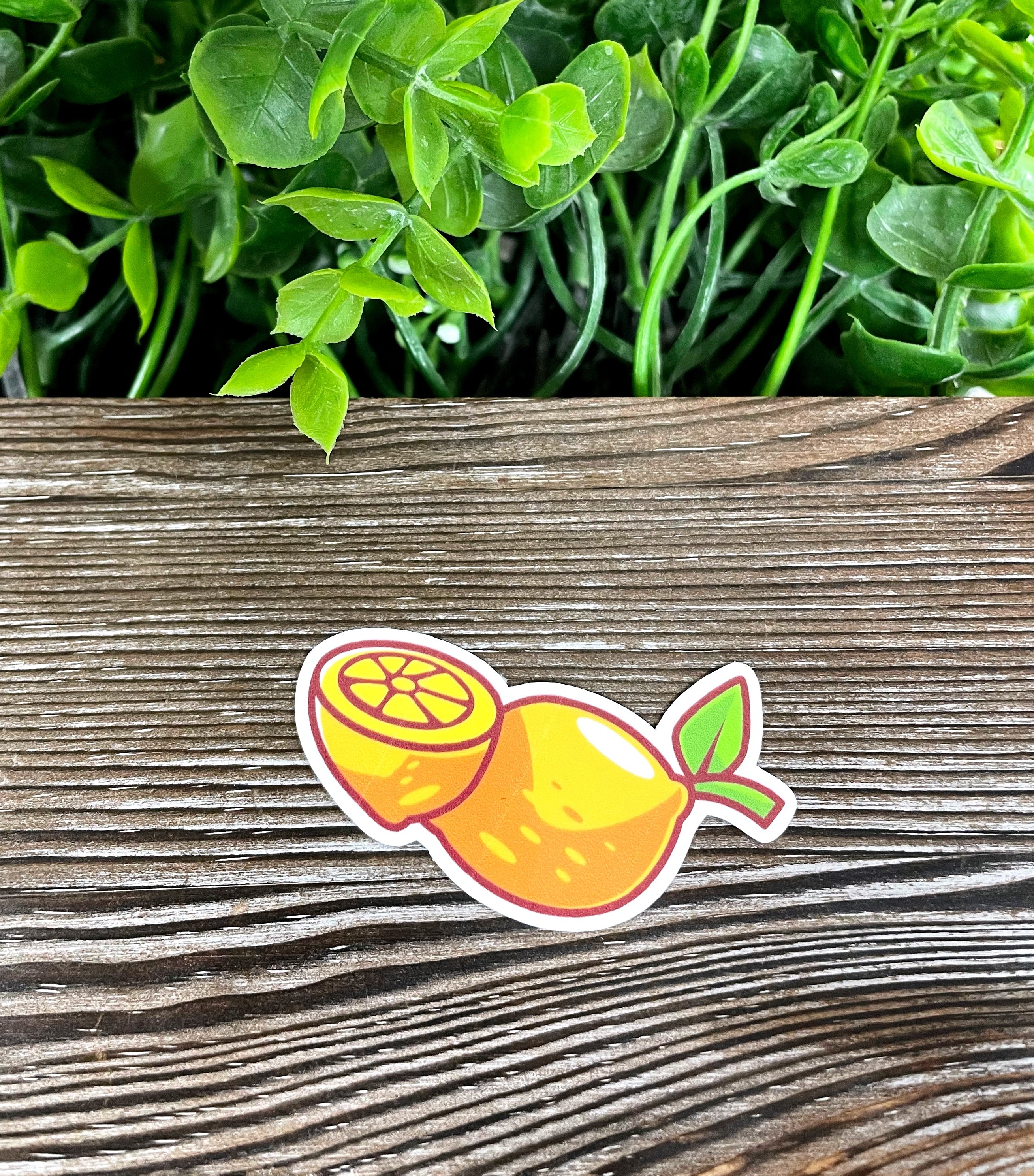 A vibrant yellow lemon die cut vinyl sticker on a smooth surface, showcasing its bright color and water-resistant laminate finish.