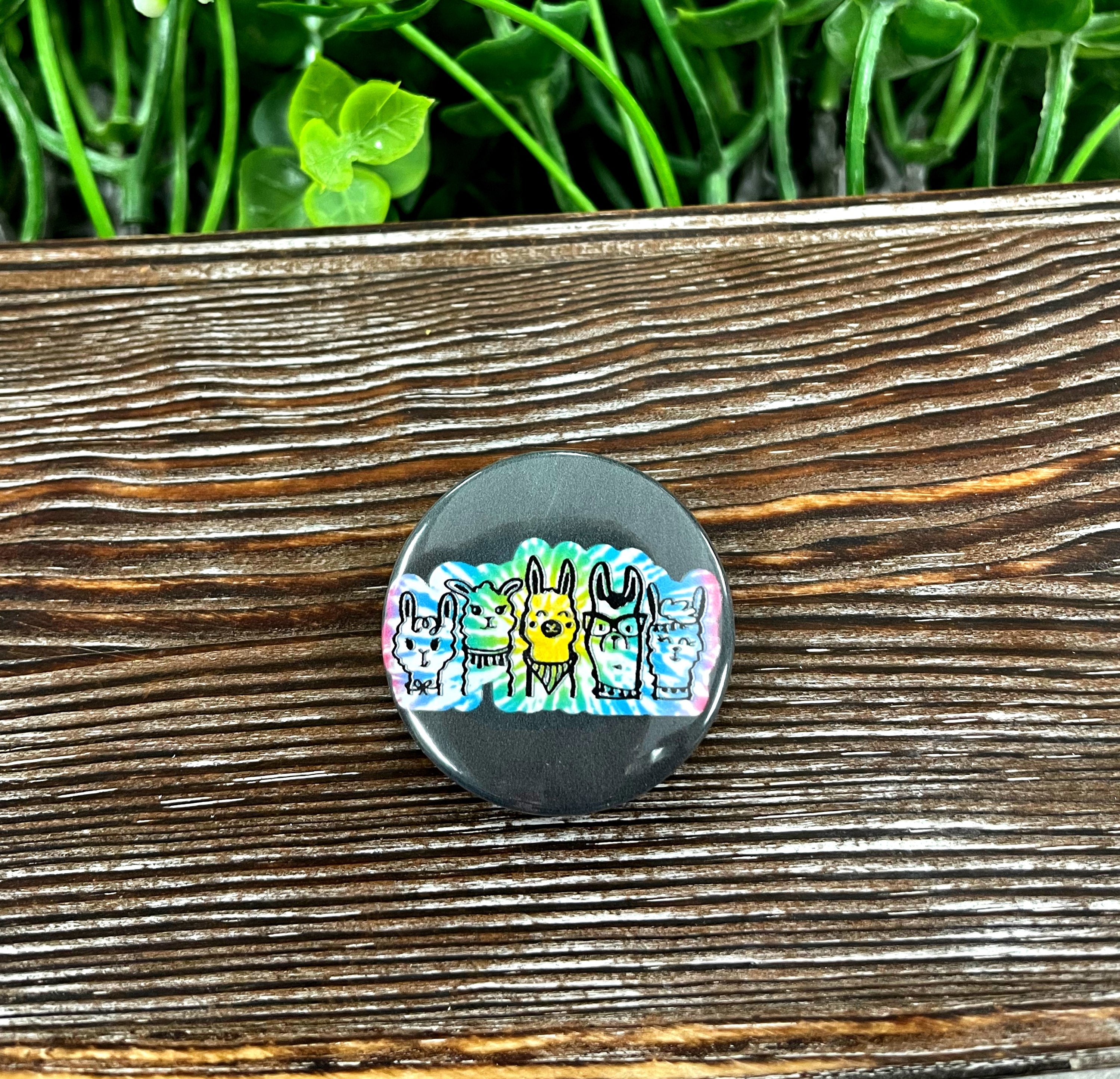 A colorful 1.25-inch button featuring a tie dye llama graphic, perfect for personalizing bags and masks.