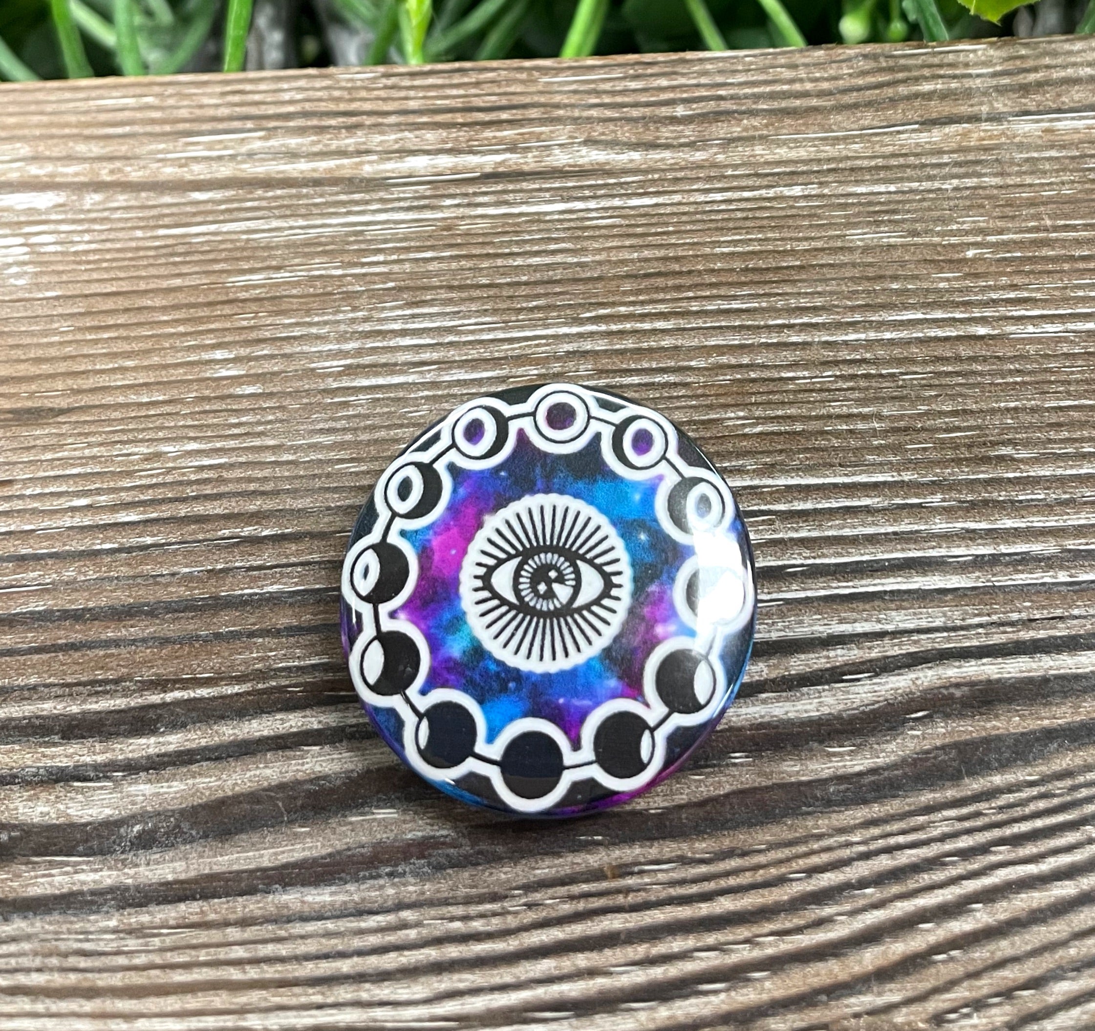 Galaxy Third Eye graphic art button pin, 1.25 inches, featuring a vibrant cosmic design with moon phases.