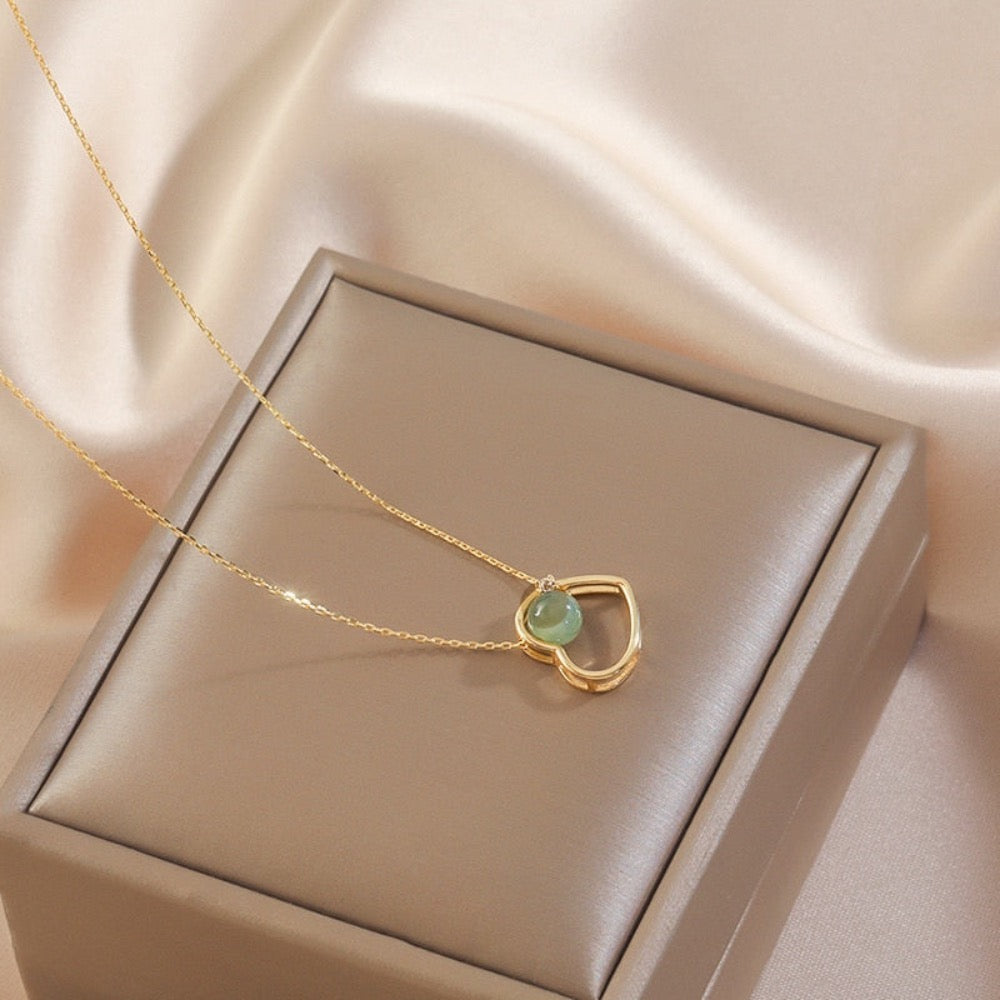 A beautiful golden heart-themed jade necklace featuring a heart-shaped pendant and a green jade bead, showcasing elegance and shine.