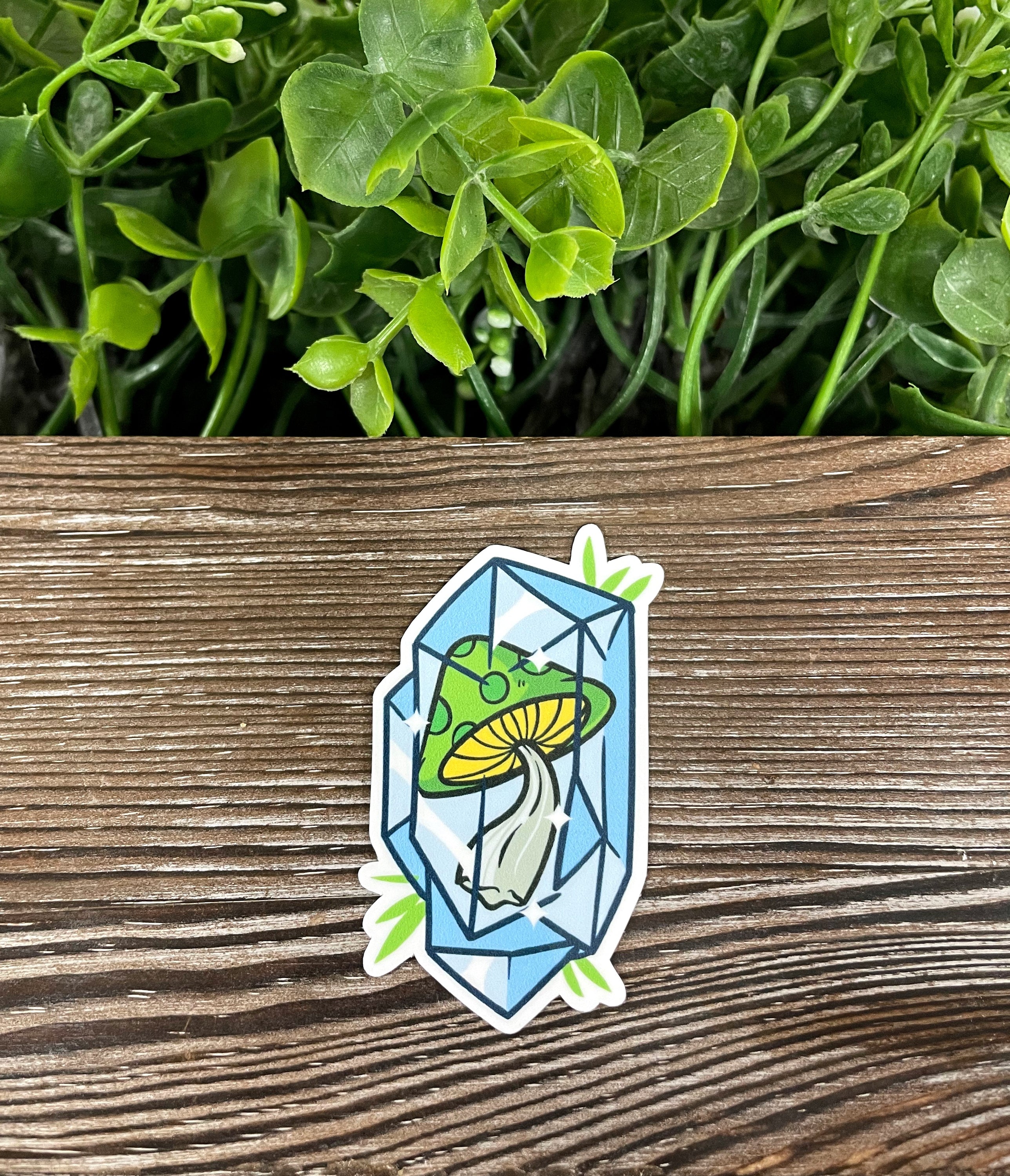 A vibrant green mushroom encased in a blue crystal, showcasing a unique die cut vinyl sticker design perfect for personalizing various surfaces.
