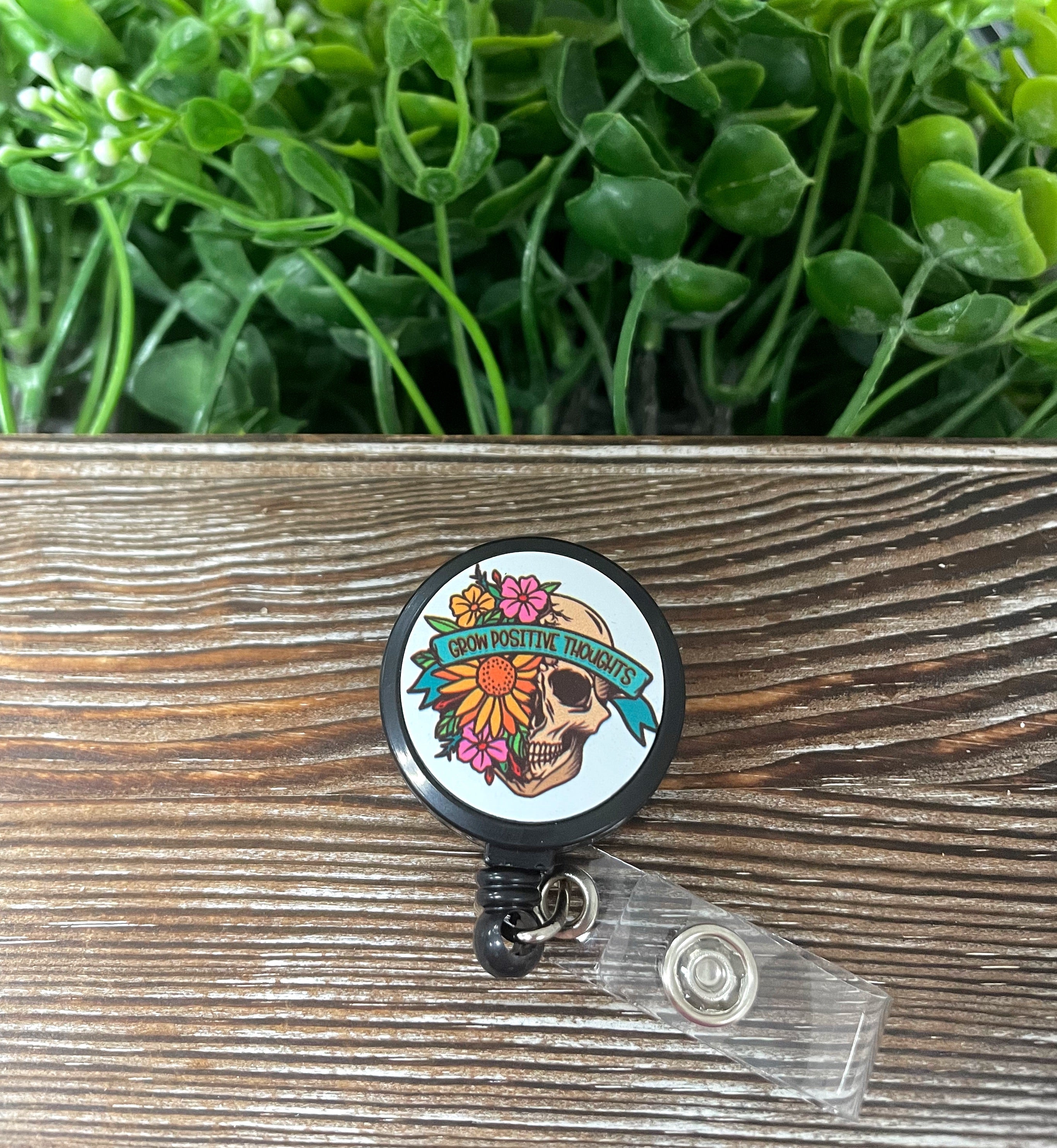 Retractable badge reel featuring a skull and flowers design, showcasing vibrant colors and quality metal construction.
