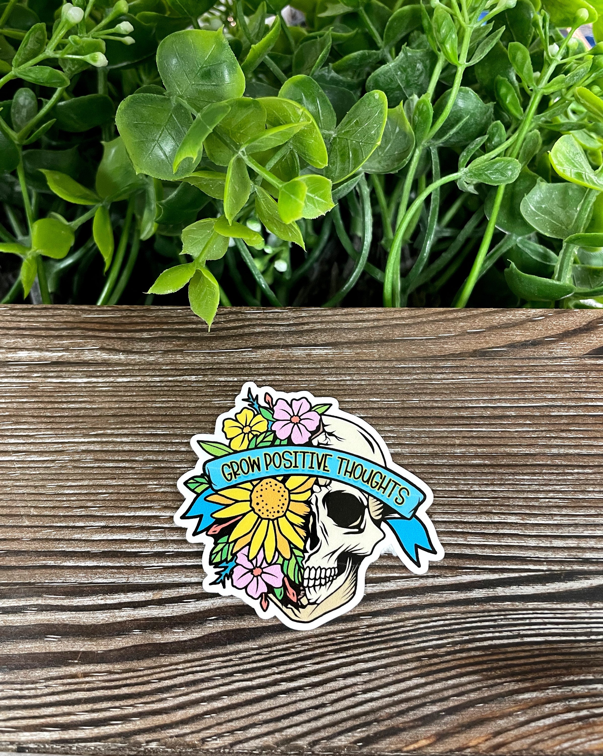 Die cut vinyl sticker featuring a skull with flowers, showcasing vibrant colors and intricate details, perfect for personalizing various surfaces.