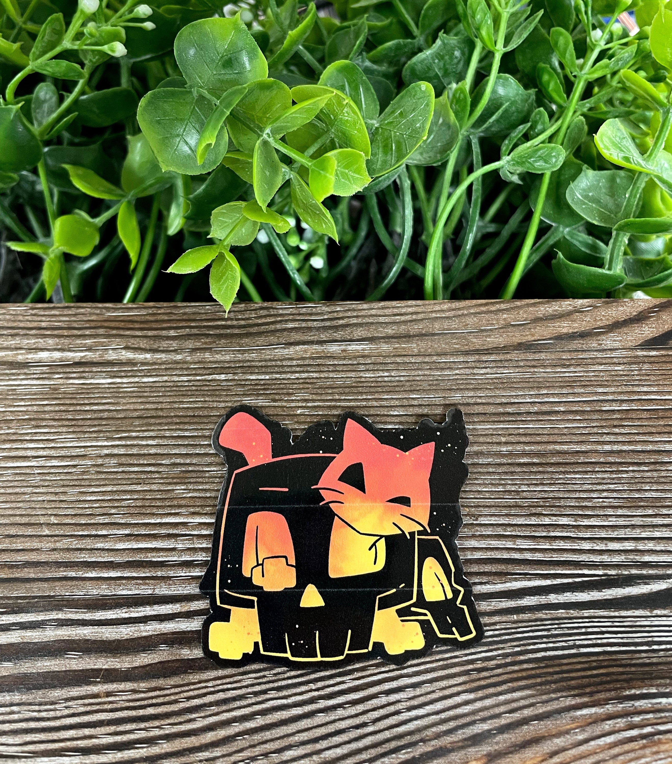 A vibrant Halloween-themed die cut vinyl sticker featuring an orange cat inside a black skull, perfect for personalizing various items.