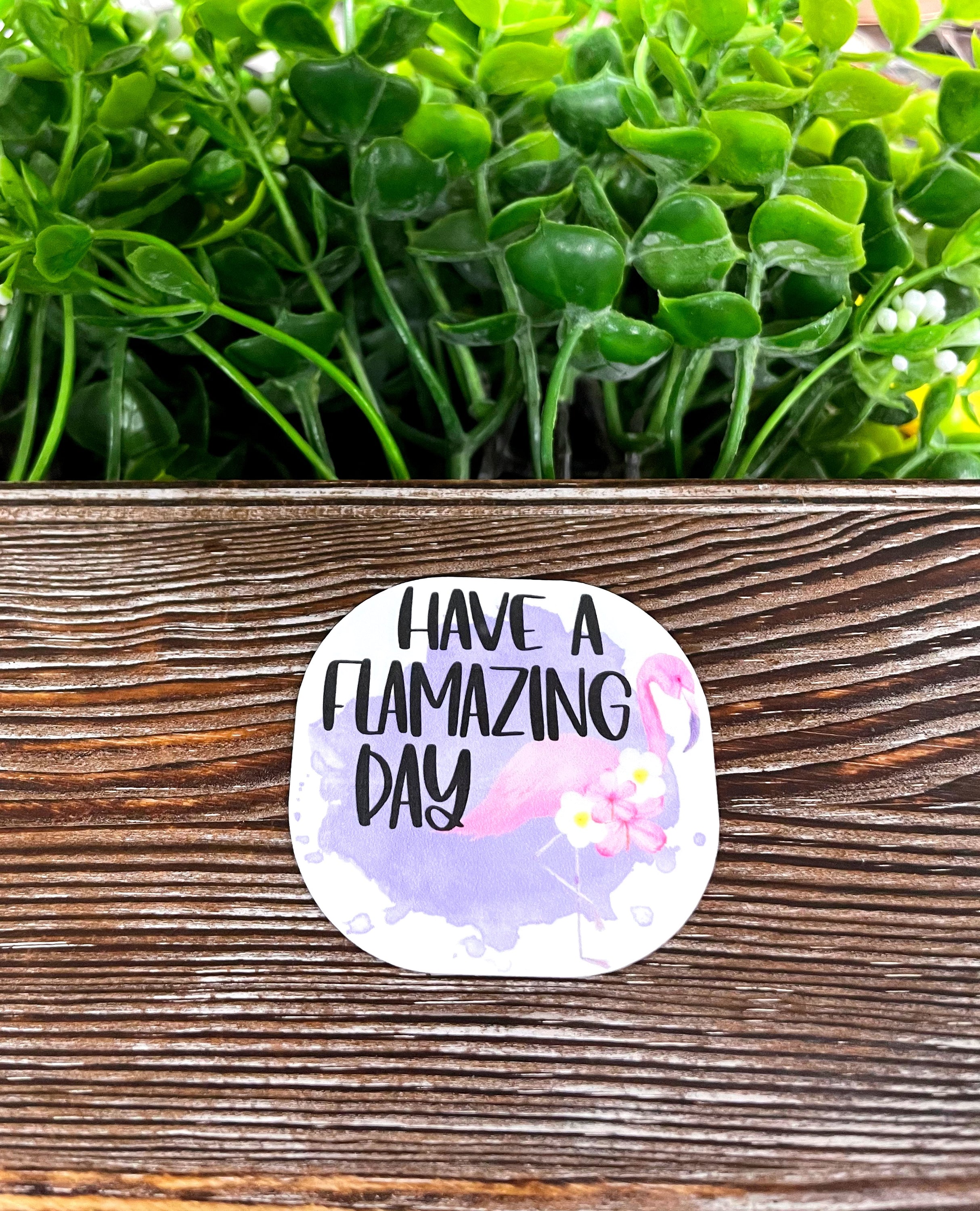 Colorful die cut vinyl sticker featuring a flamingo design with the text 'Have a Flamazing Day'. Perfect for personalizing items.