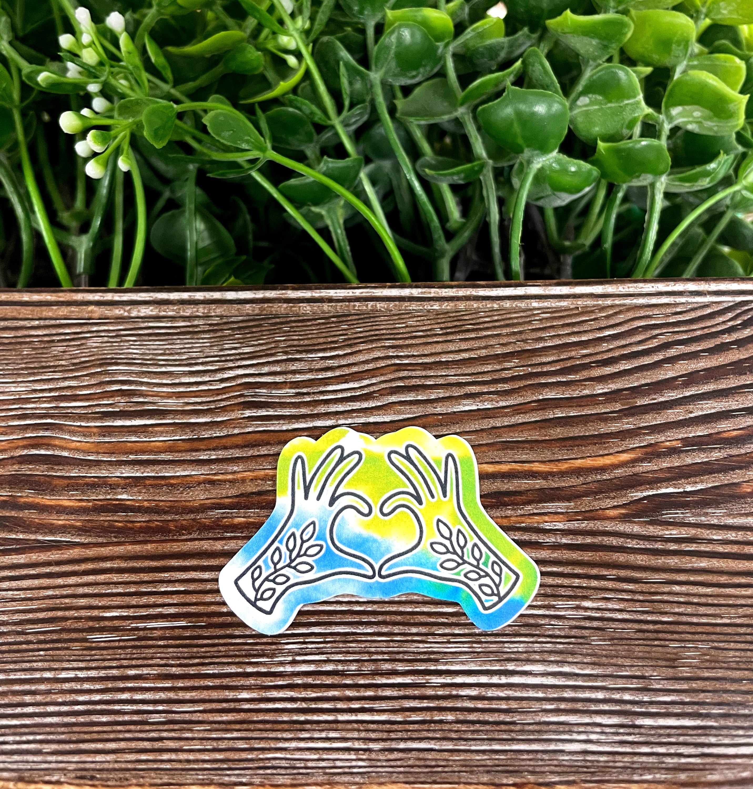 Healing Hands die cut sticker featuring vibrant graphic art on a smooth vinyl surface, ideal for personalizing various items.