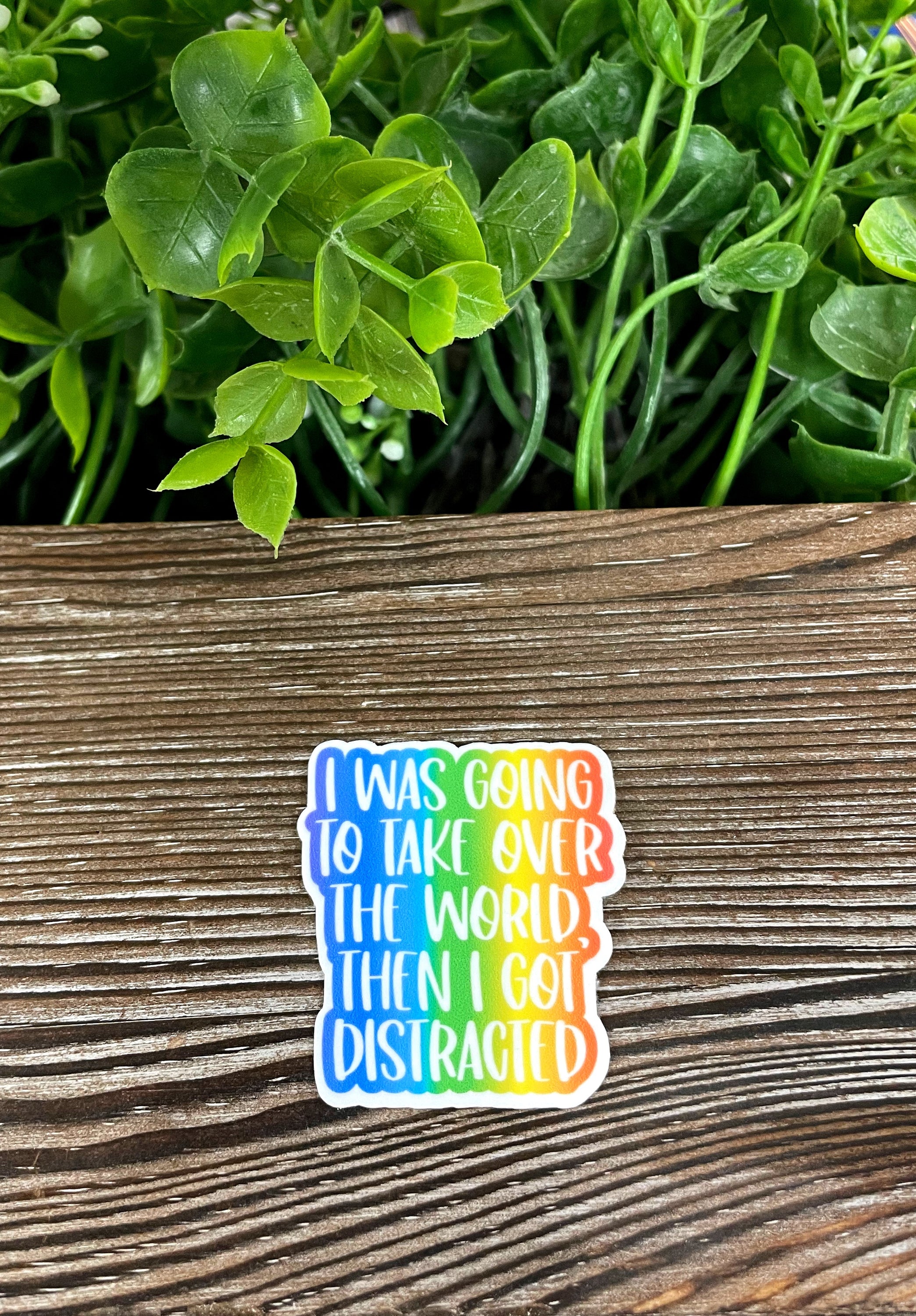 Die cut sticker featuring the phrase 'I Was Going to Take Over the World but then I Got Distracted' with a colorful design, perfect for personalizing items.