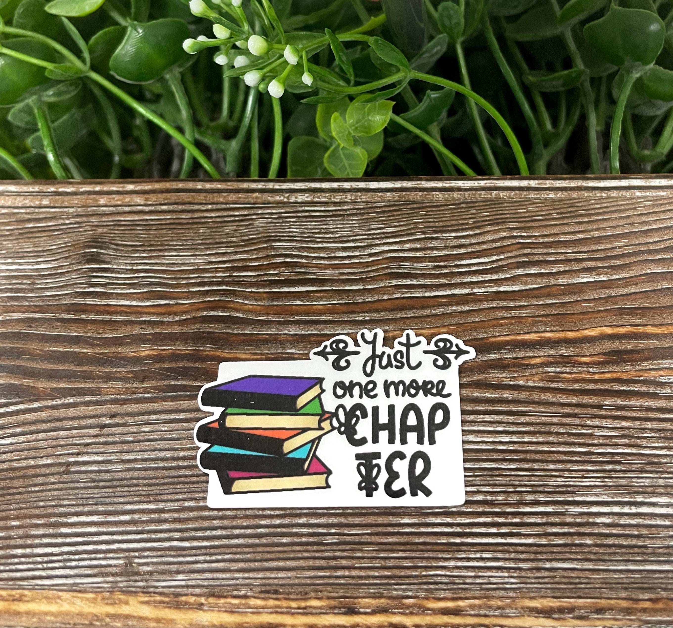 Die cut sticker featuring the phrase 'Just One More Chapter' with a book stack design, perfect for book lovers.