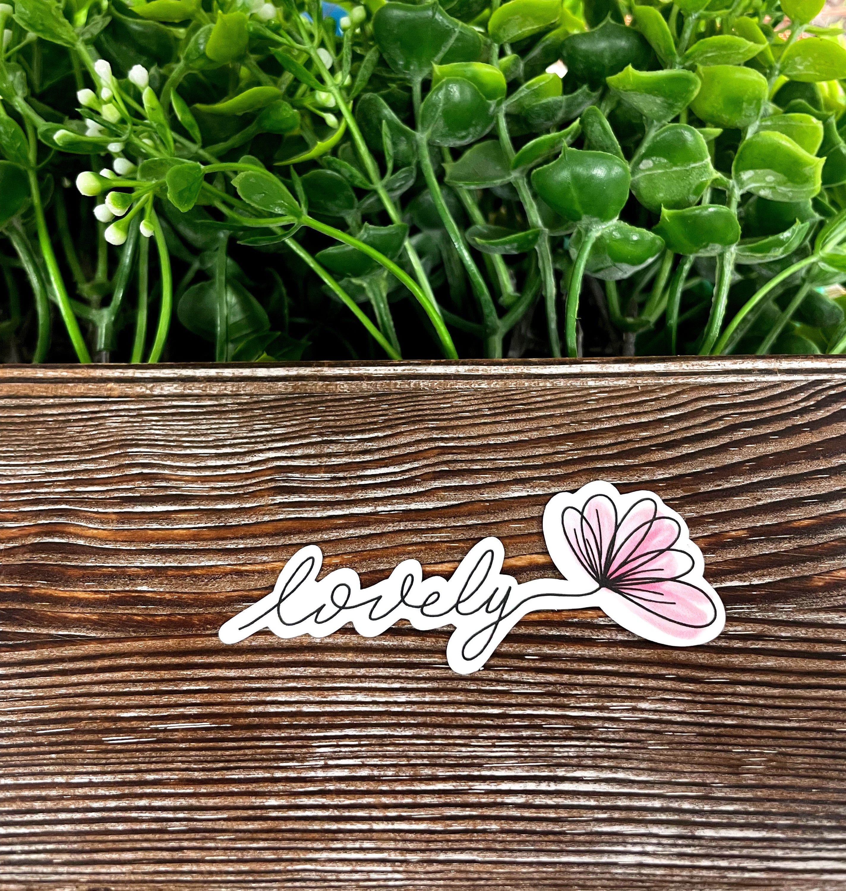 Lovely Script Lettering die cut sticker on a smooth surface, showcasing vibrant colors and a stylish design.
