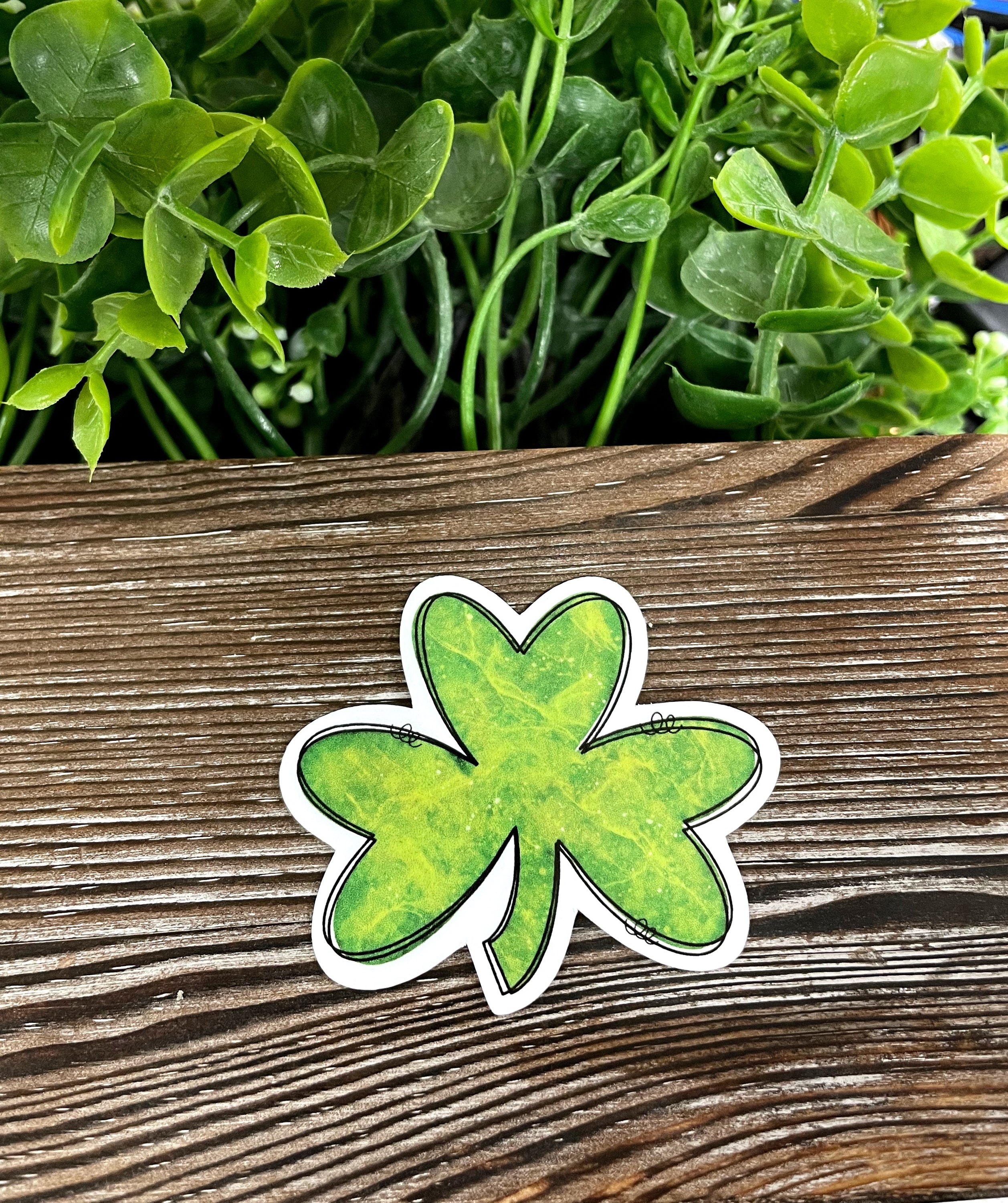 Lucky Clover die cut vinyl sticker on a smooth surface, showcasing its vibrant colors and intricate design.