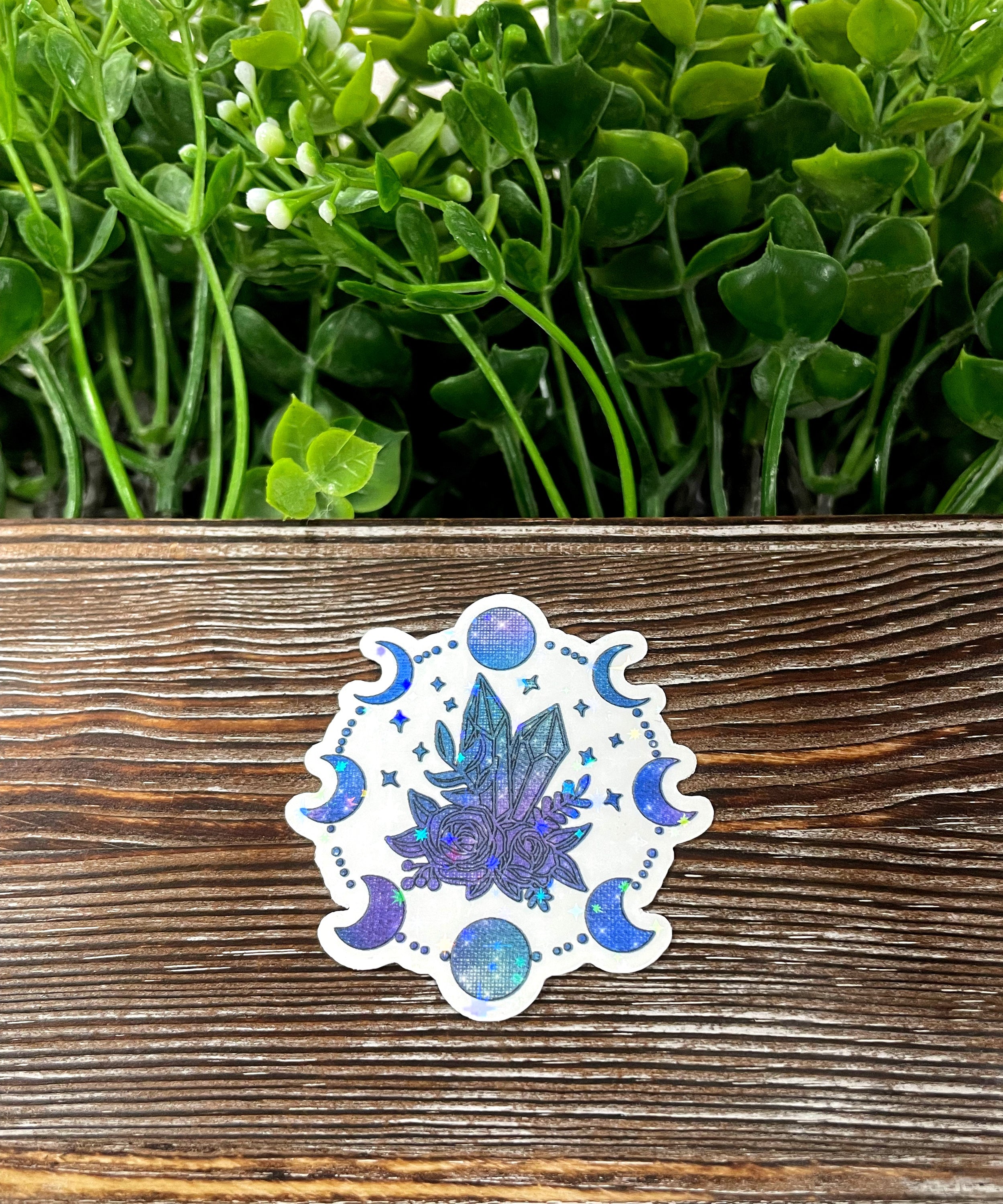 Moon Phases Crystals Sticker featuring intricate graphic art on a vinyl surface, showcasing celestial designs.