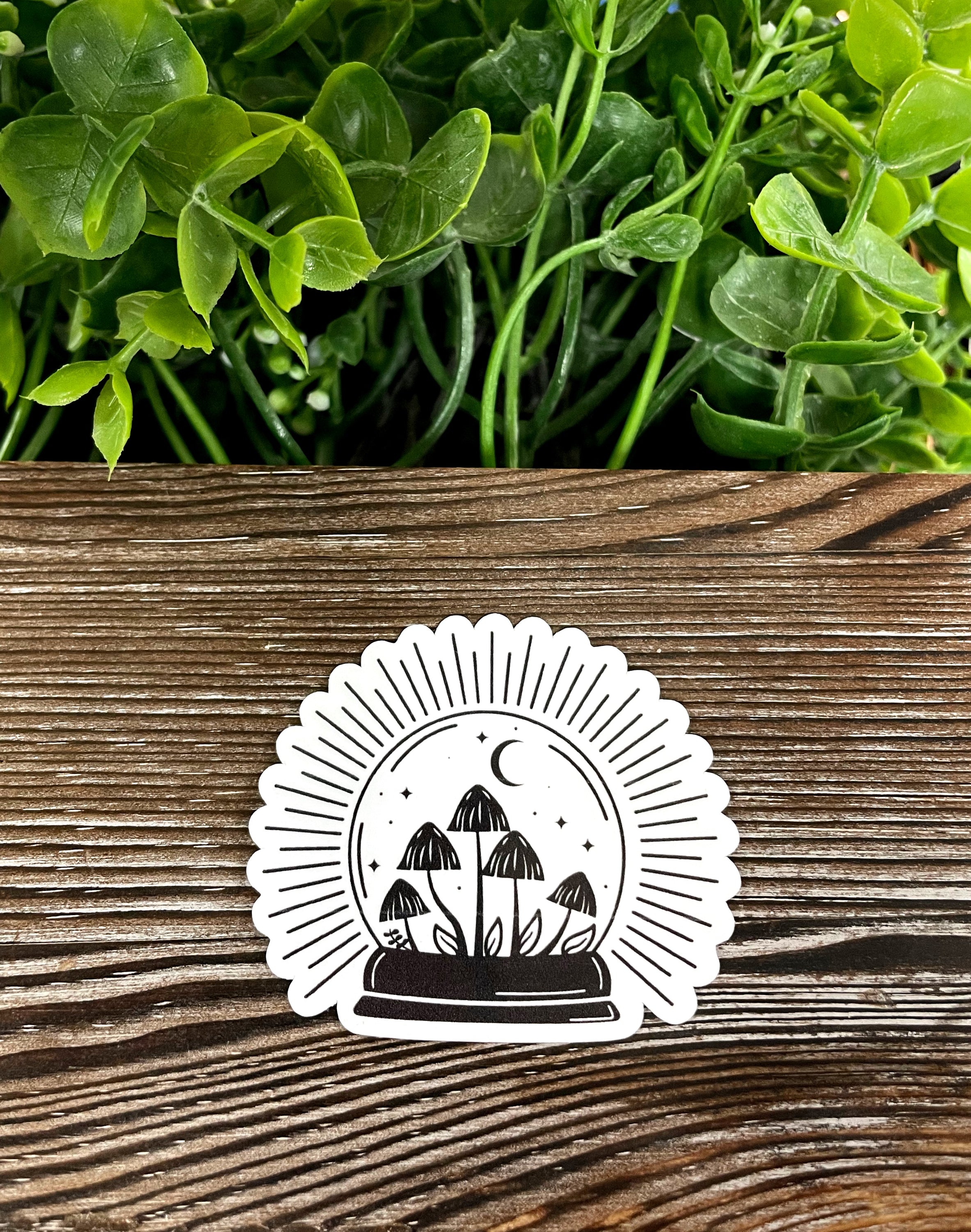 A vibrant die cut vinyl sticker featuring mushrooms inside a crystal ball, showcasing a boho aesthetic with colorful details.