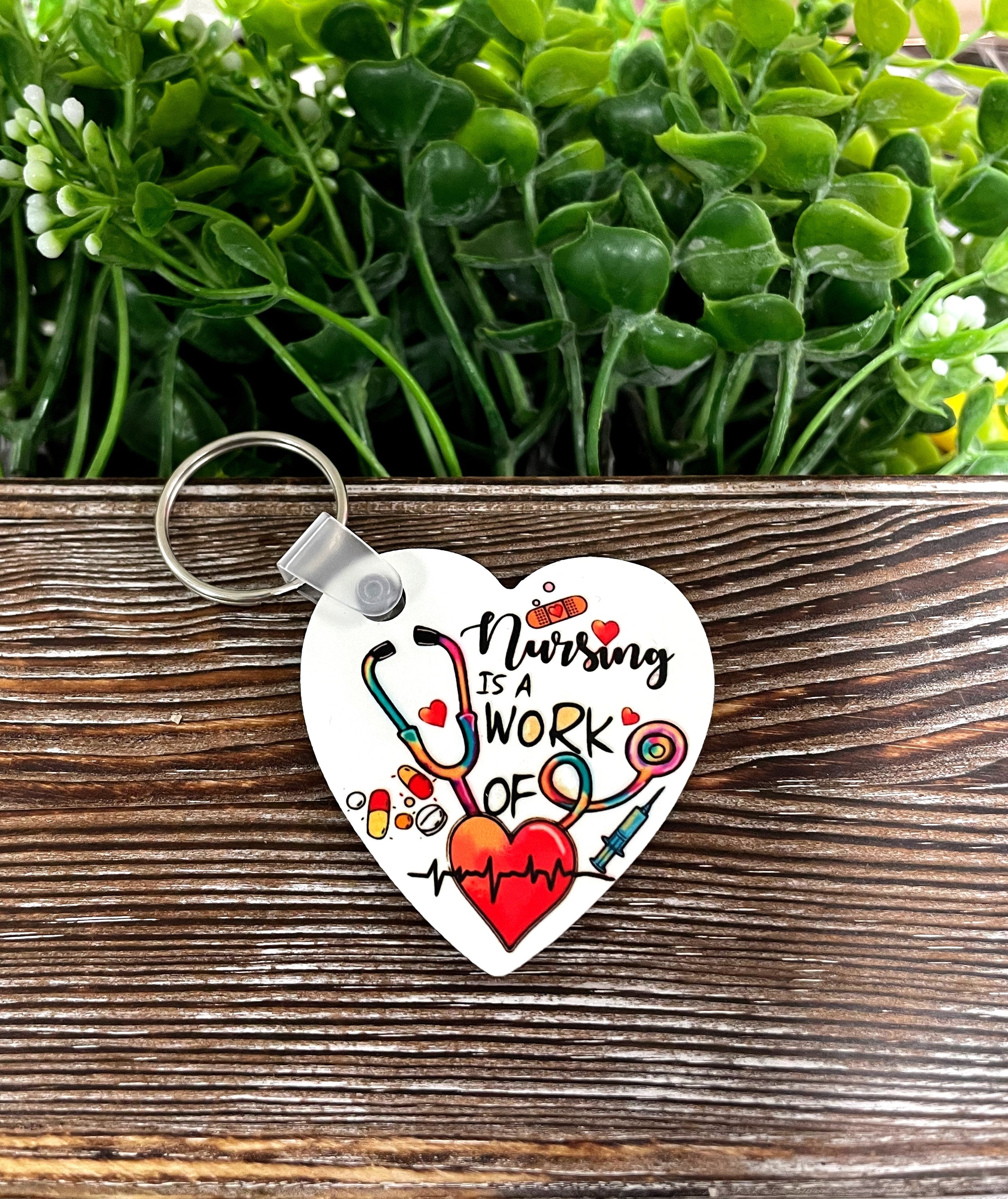 A lightweight MDF heart keychain with the phrase 'Nursing is a Work of Heart', showcasing a boho fun style.