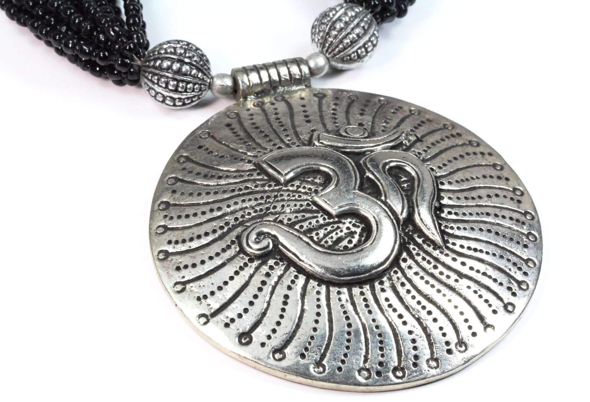 Om in Cosmos Statement Necklace featuring black beads and silvertone OM charms, handcrafted for spiritual elegance.