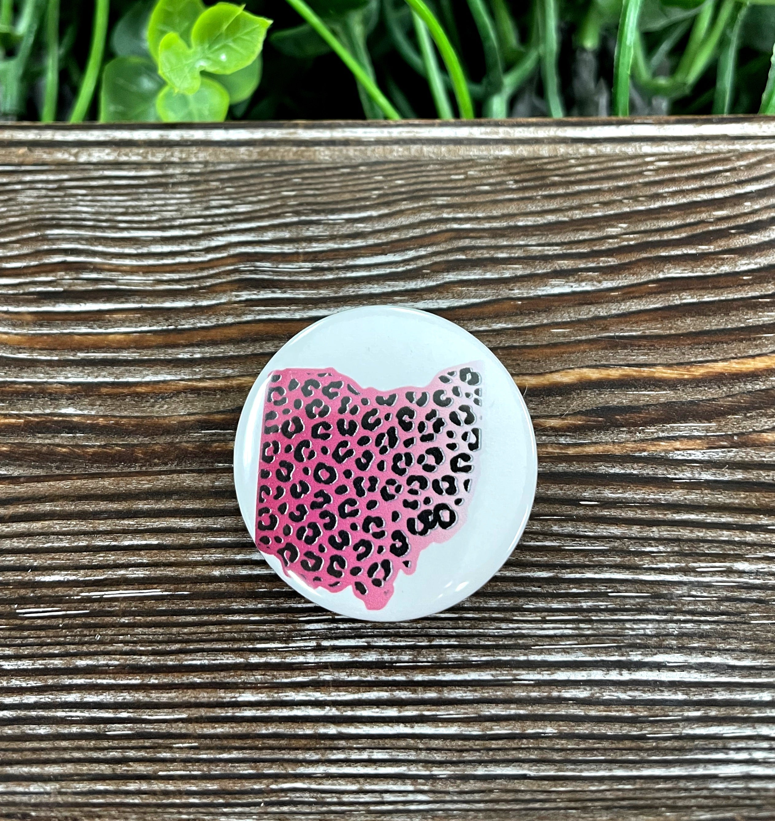 A vibrant Pink Leopard Cheetah Ohio Graphic Art Button, 1.25 inches in size, showcasing a playful design perfect for accessories.