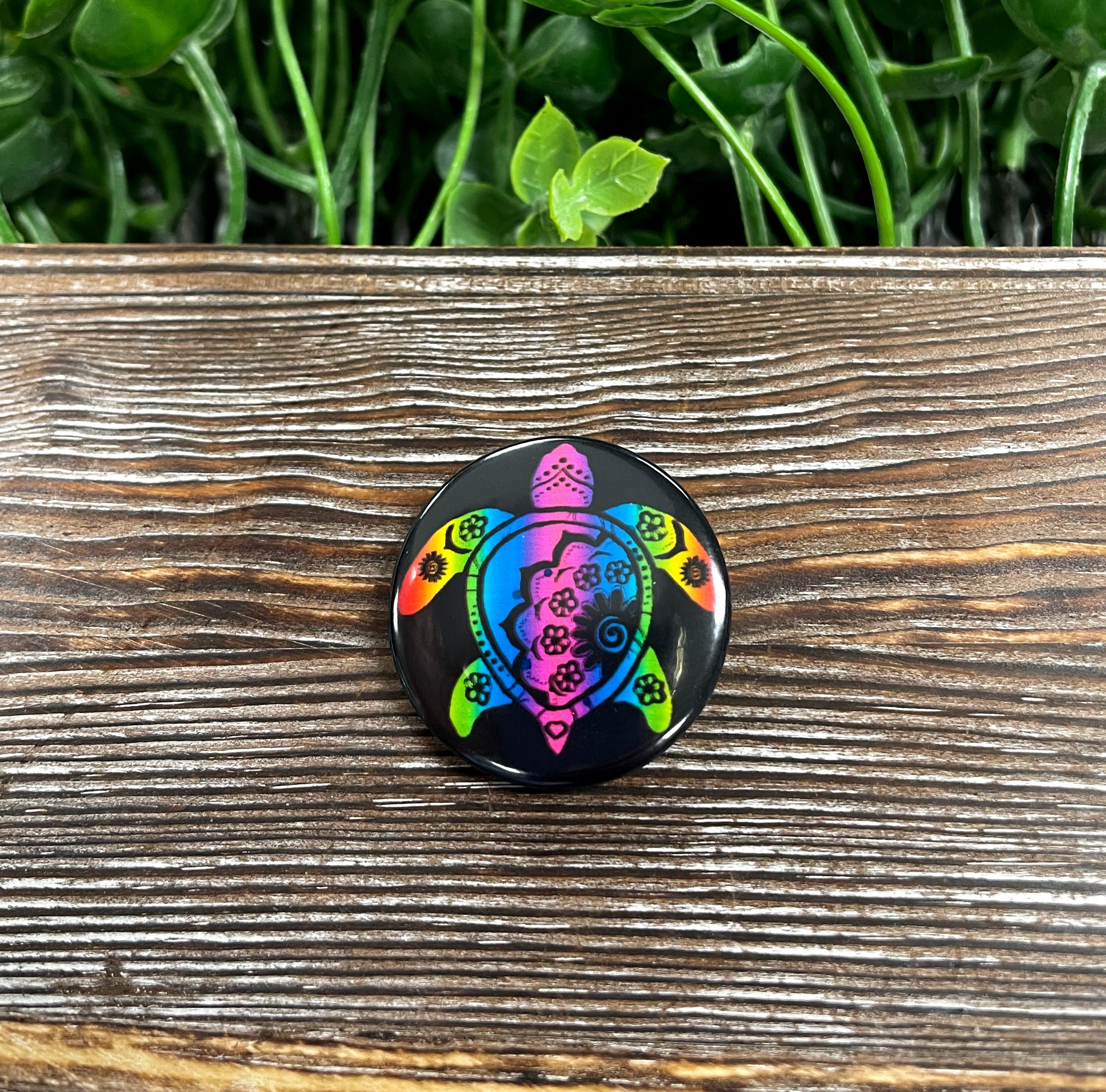 A colorful 1.25-inch button featuring a rainbow mandala turtle design, perfect for personalizing bags and masks.