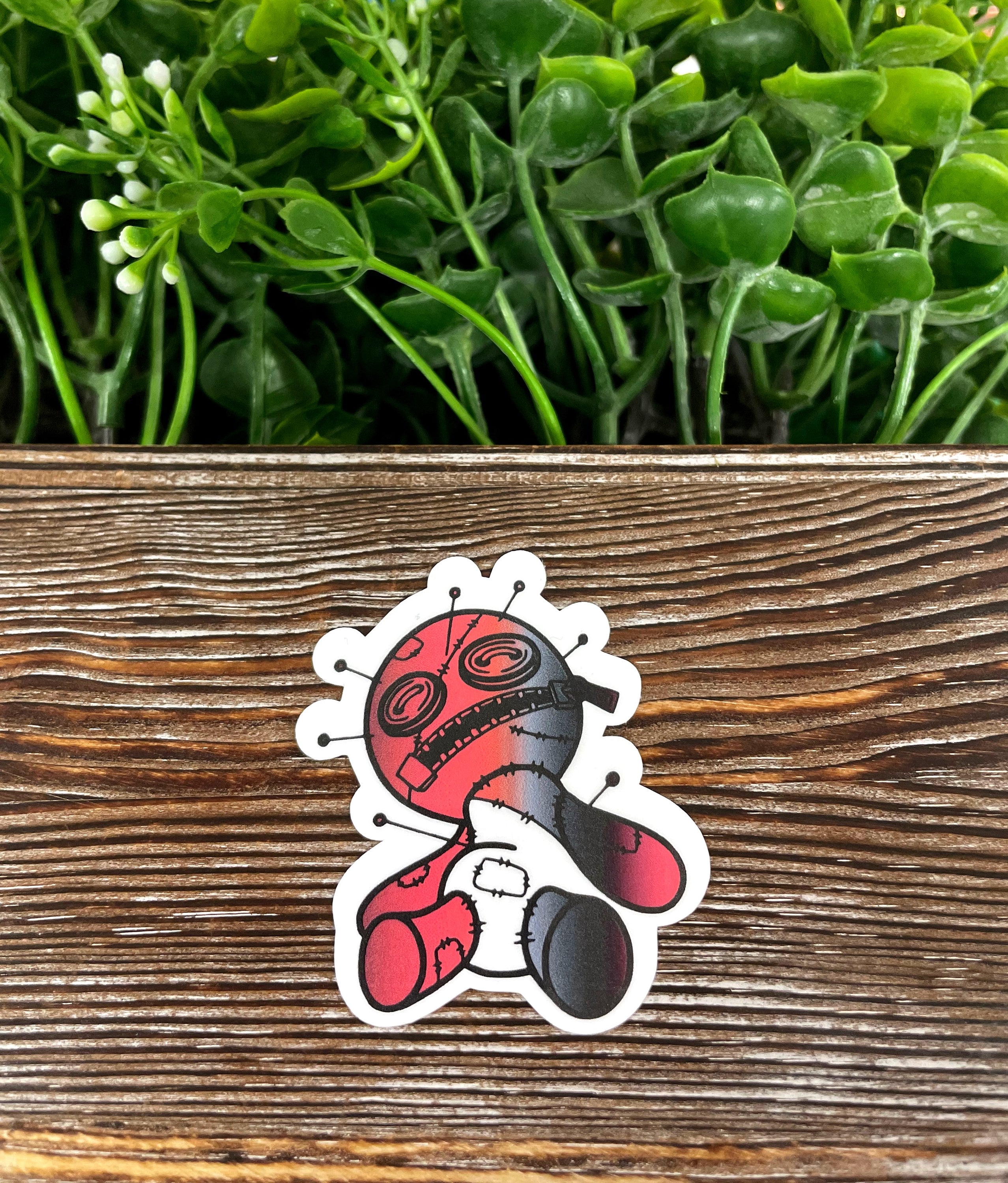 A vibrant Red and Black Voodoo Doll die cut vinyl sticker, showcasing intricate details and a boho design, perfect for personalizing various surfaces.