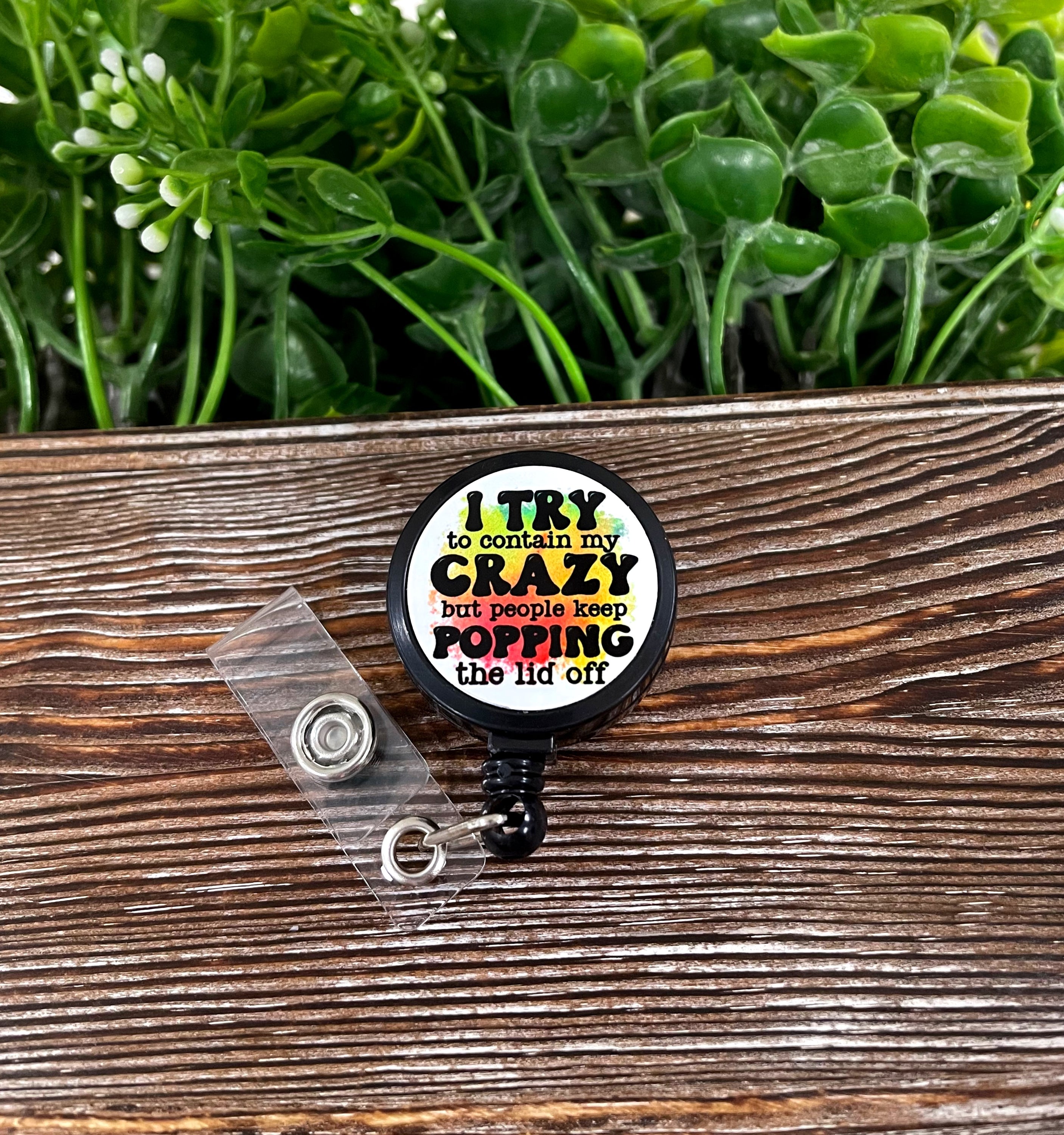 A colorful retractable badge reel featuring a snarky sarcasm quote, designed with a metal blank and plastic base, measuring 1.2 inches in diameter.