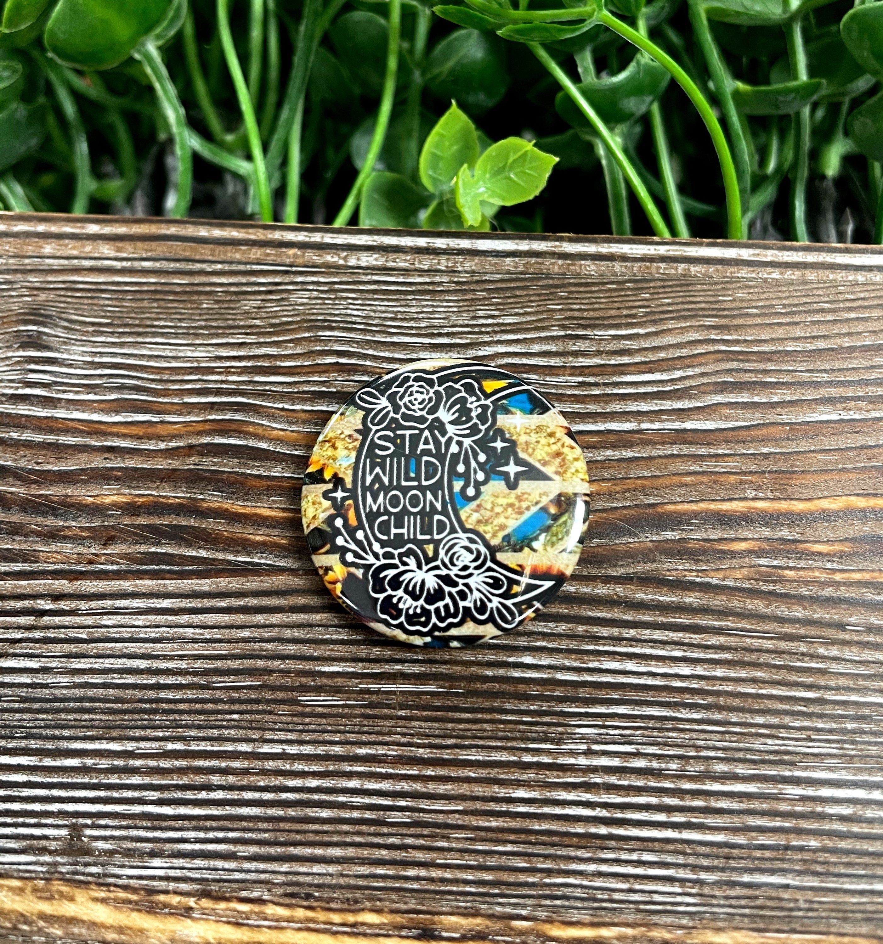 Stay Wild Moon Child graphic art button with a gold background, measuring 1.25 inches, showcasing vibrant colors and intricate design.