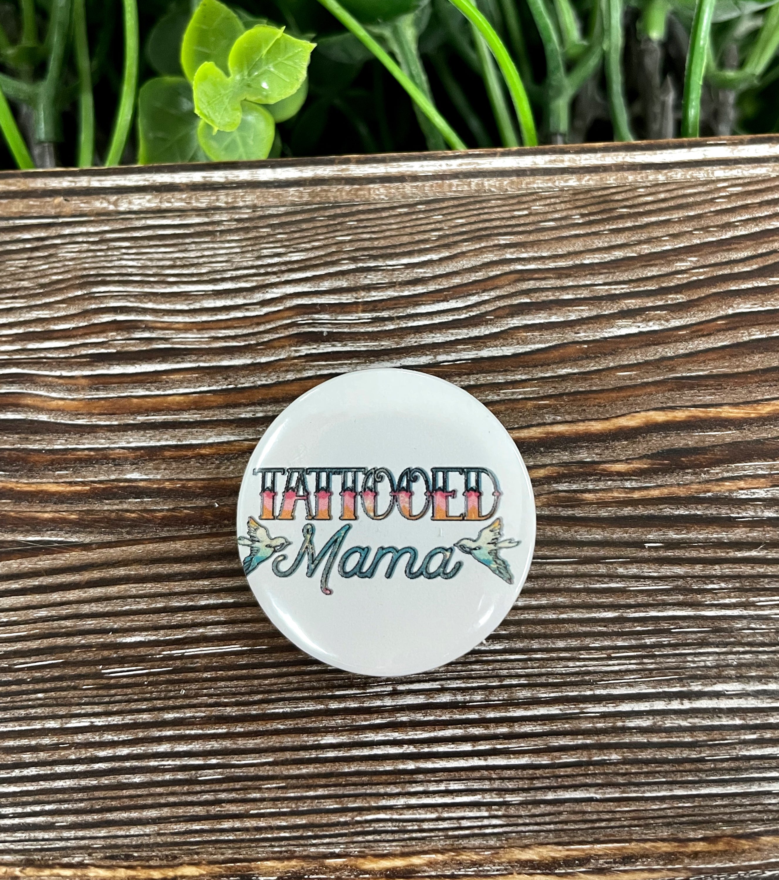 Tattooed Mama Graphic Art Button, 1.25 inches, featuring vibrant tattoo-inspired design on a durable plastic back.
