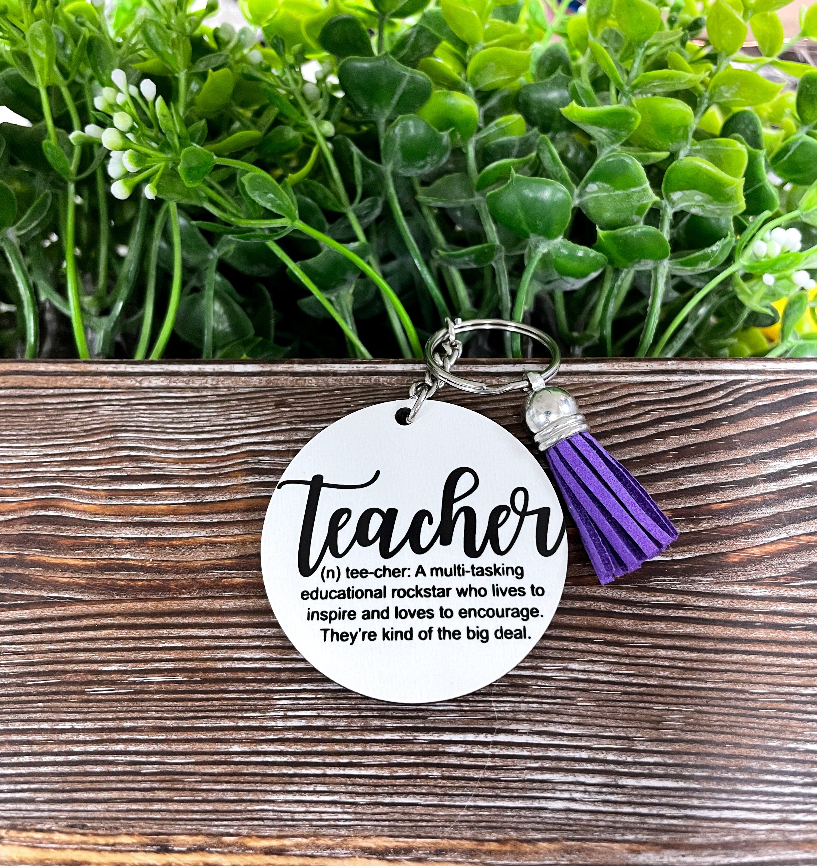 A colorful MDF round keychain featuring the definition of a teacher, lightweight and stylish, perfect for everyday use.