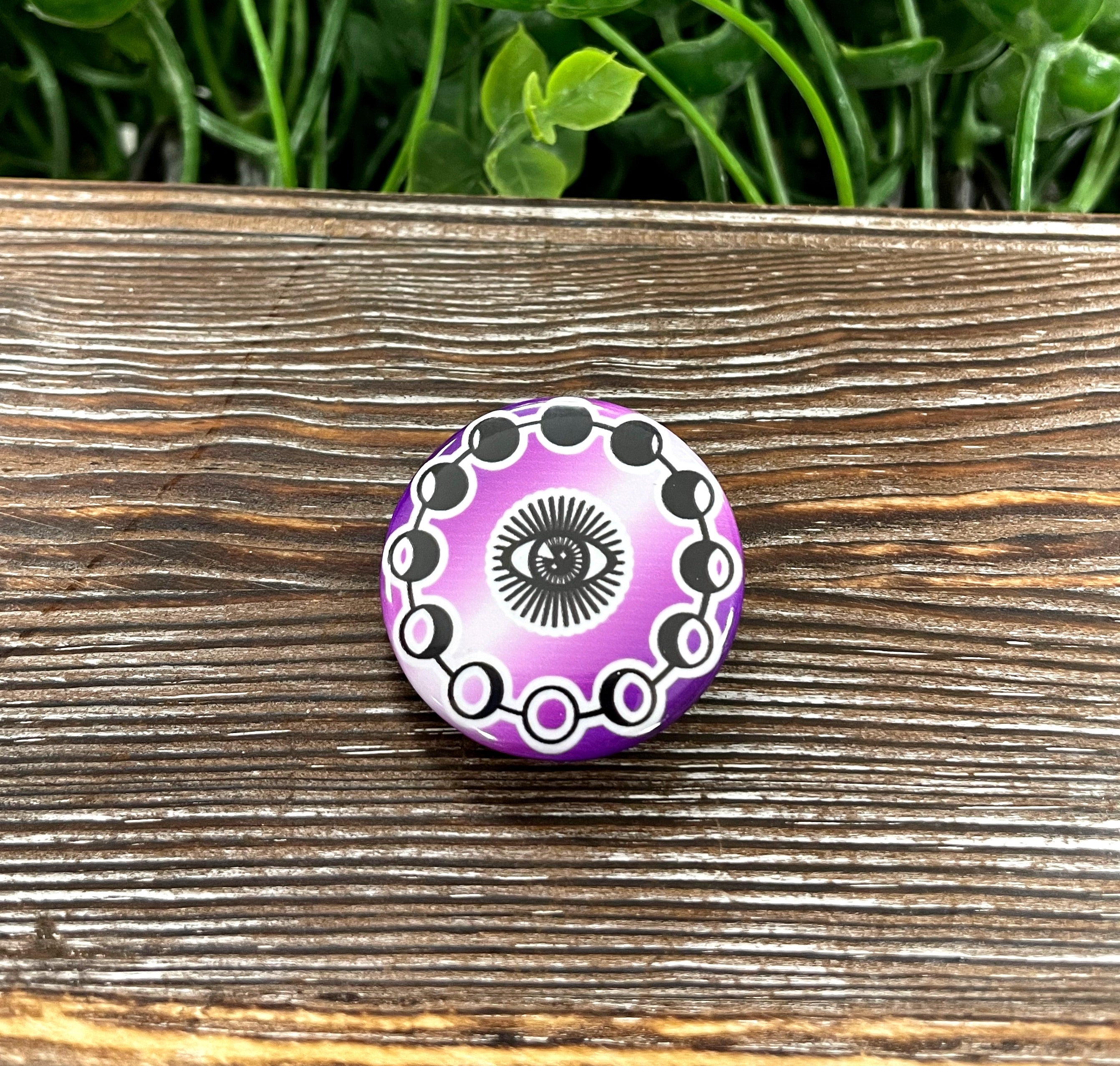 Third Eye Moon Phases graphic art button in purple and white, showcasing intricate moon designs.