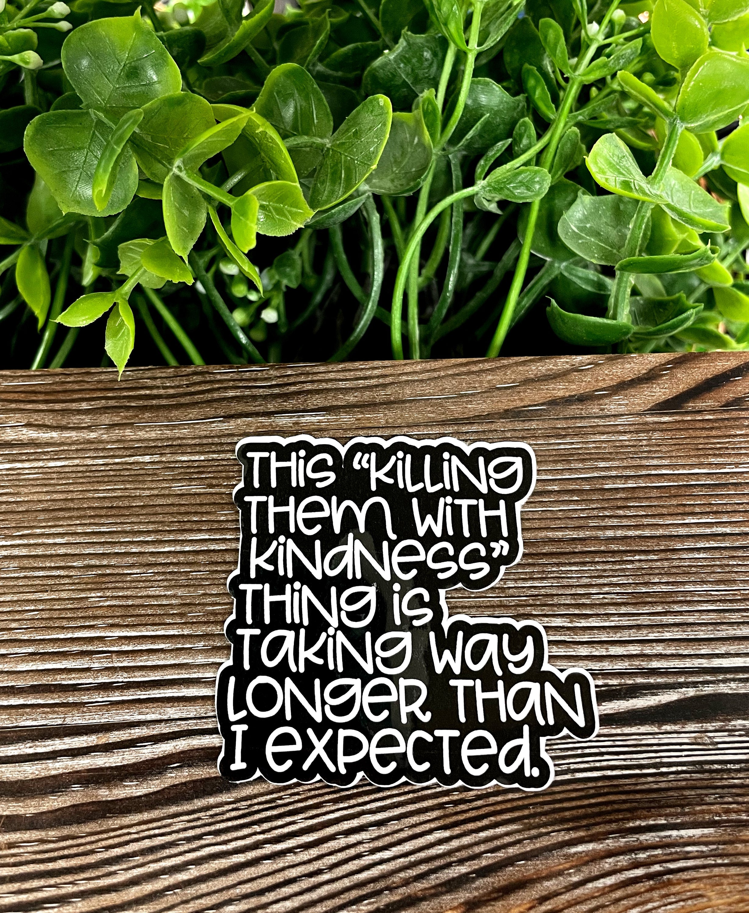 A collection of 'Killing them with Kindness' die cut stickers on a smooth surface, showcasing vibrant colors and unique designs.