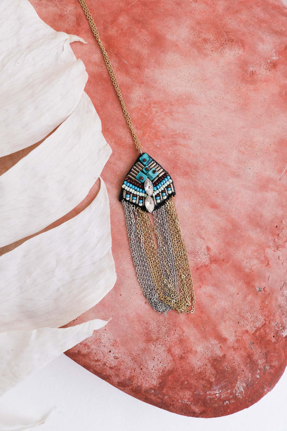 A beautiful Turquoise & Crystal Medallion Chain Necklace featuring vibrant turquoise stones and sparkling crystals, showcasing its unique handmade design.