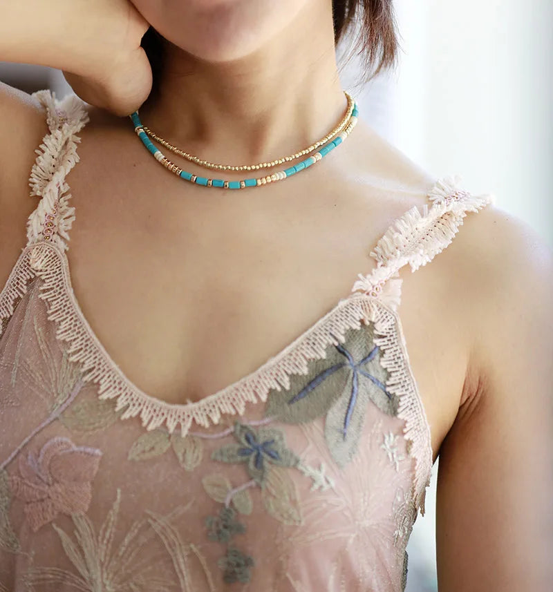 A beautiful handmade choker necklace featuring natural turquoise stone beads and gold plated seed beads, showcasing a bohemian style.