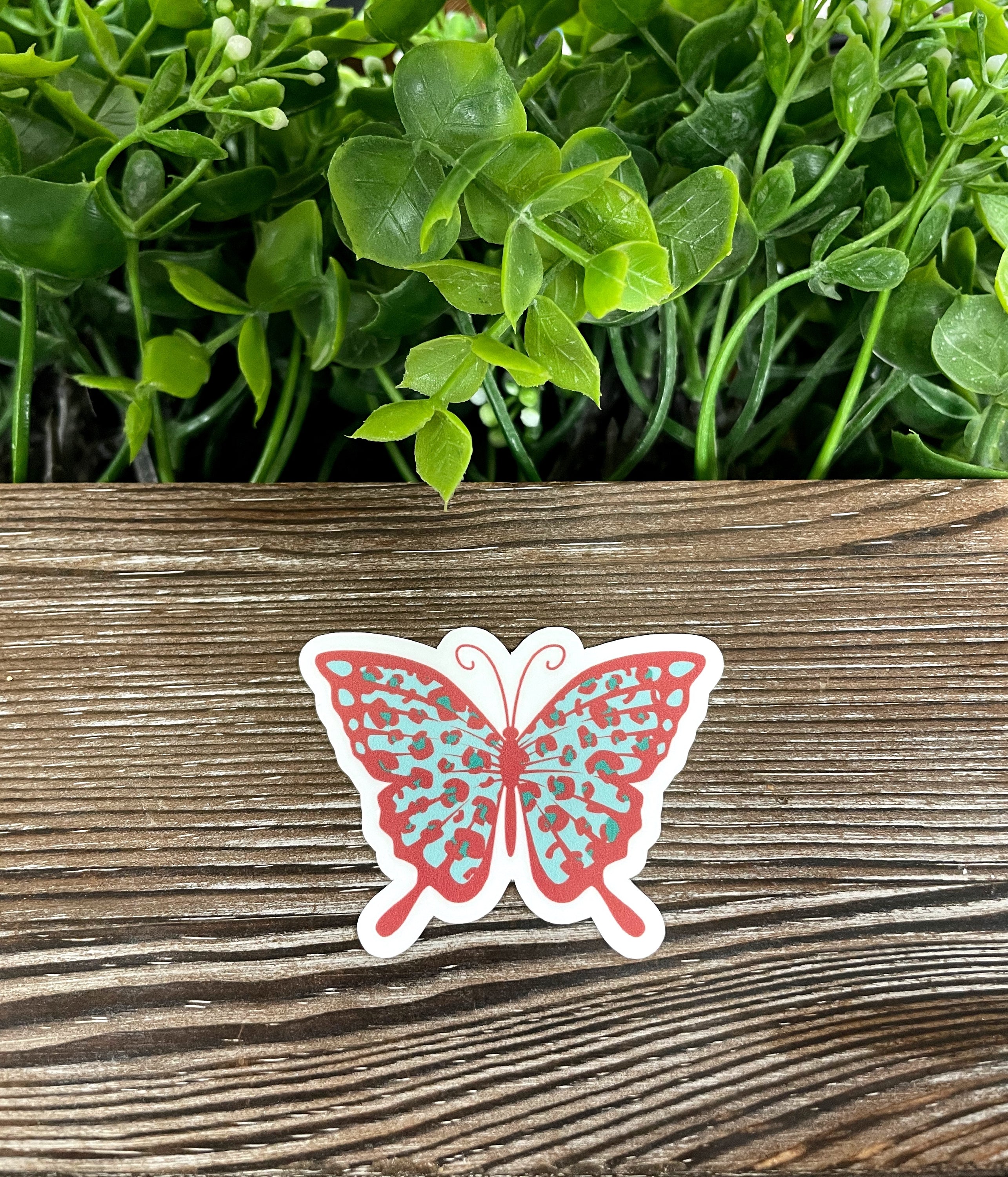 Vintage Cheetah Print Butterfly die cut vinyl sticker on a smooth surface, showcasing its vibrant colors and intricate design.