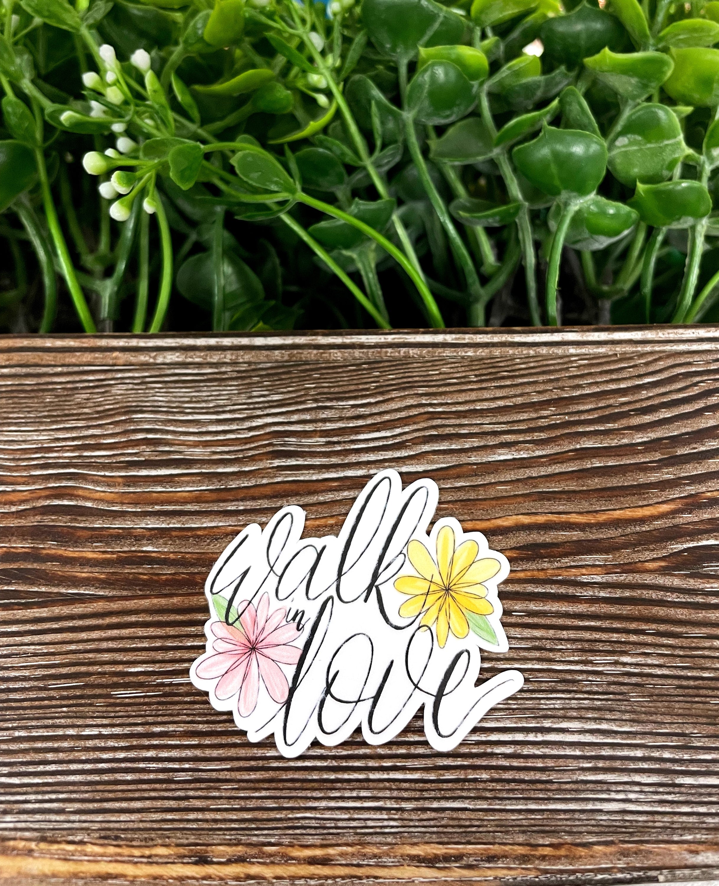 Walk In Love die cut sticker on a smooth surface, showcasing vibrant colors and inspirational design.