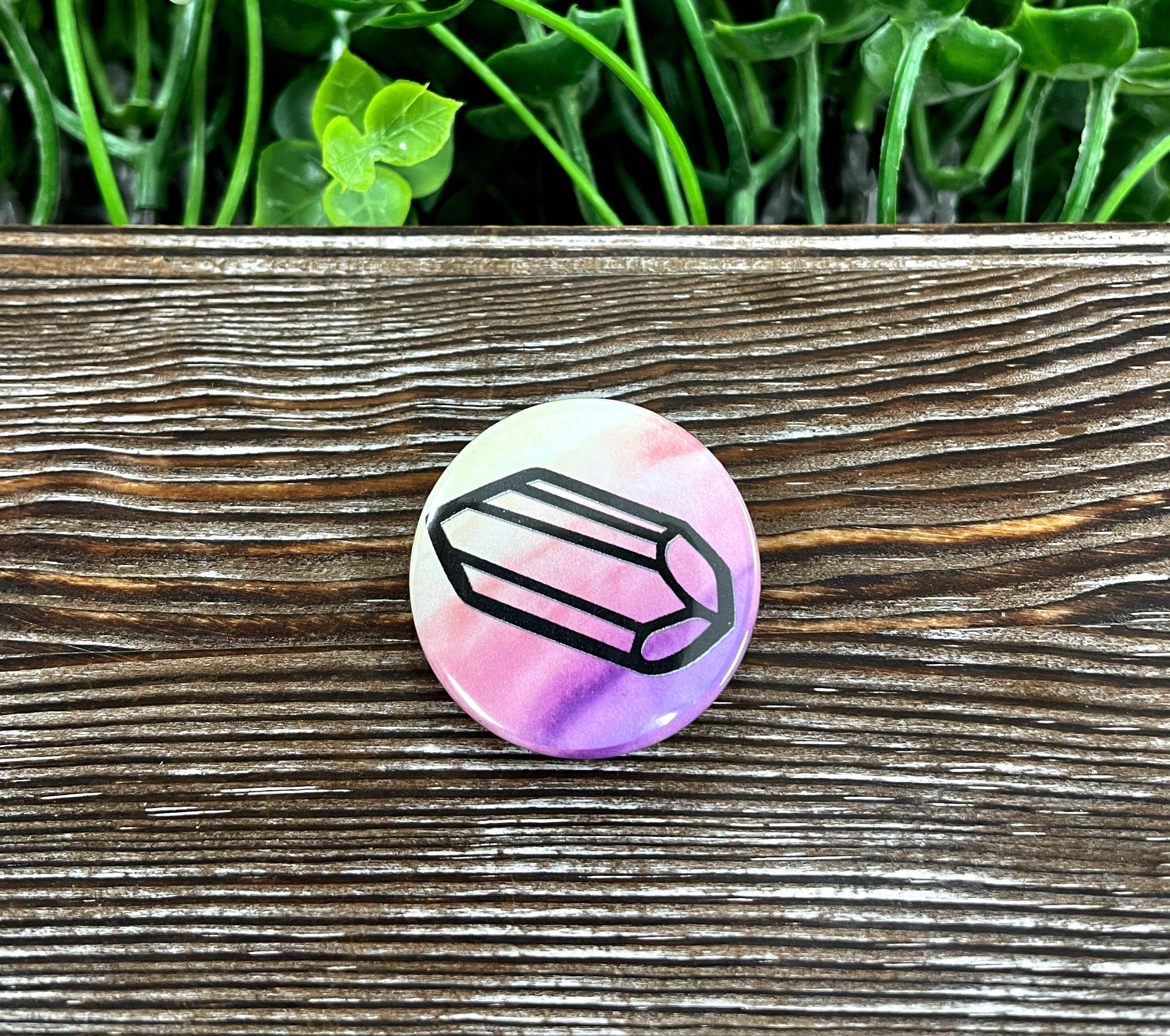 A colorful 1.25-inch button featuring a watercolor crystal gemstone design, perfect for personalizing bags and accessories.