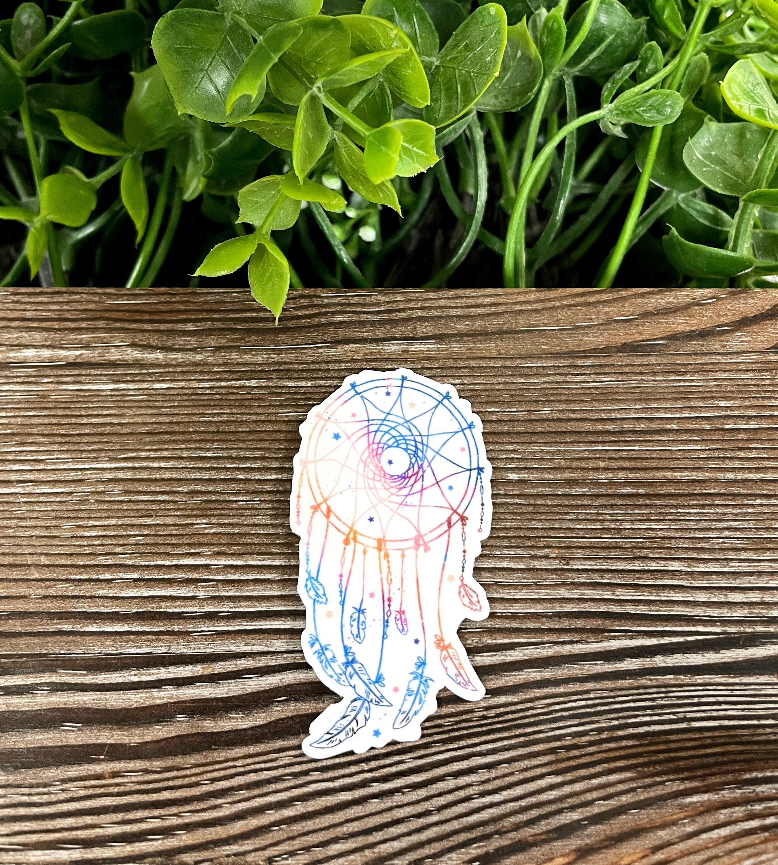 A vibrant watercolor dreamcatcher vinyl sticker featuring colorful feathers, perfect for personalizing various smooth surfaces.