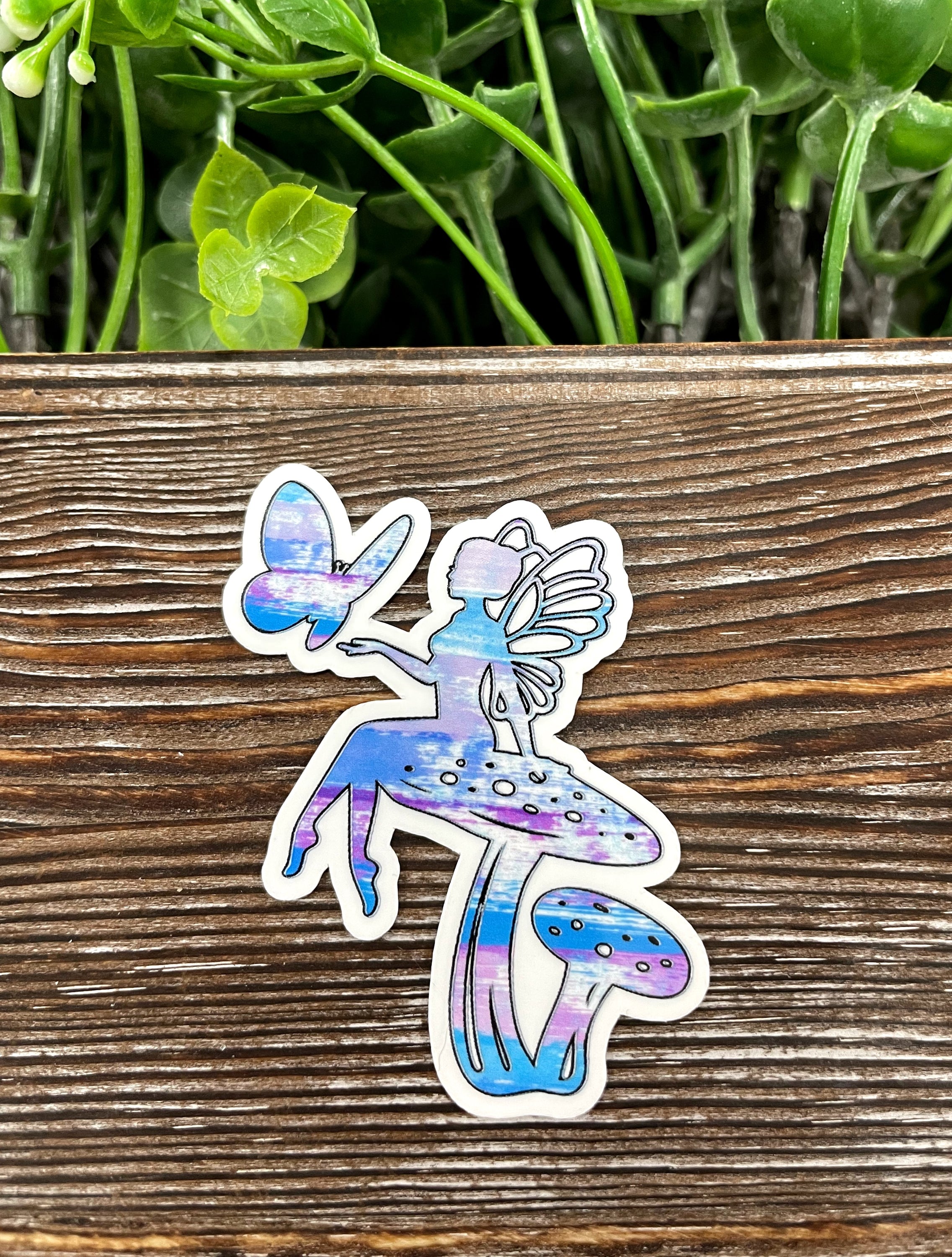 A vibrant watercolor fairy mushroom die cut sticker on a smooth surface, showcasing intricate details and colors.
