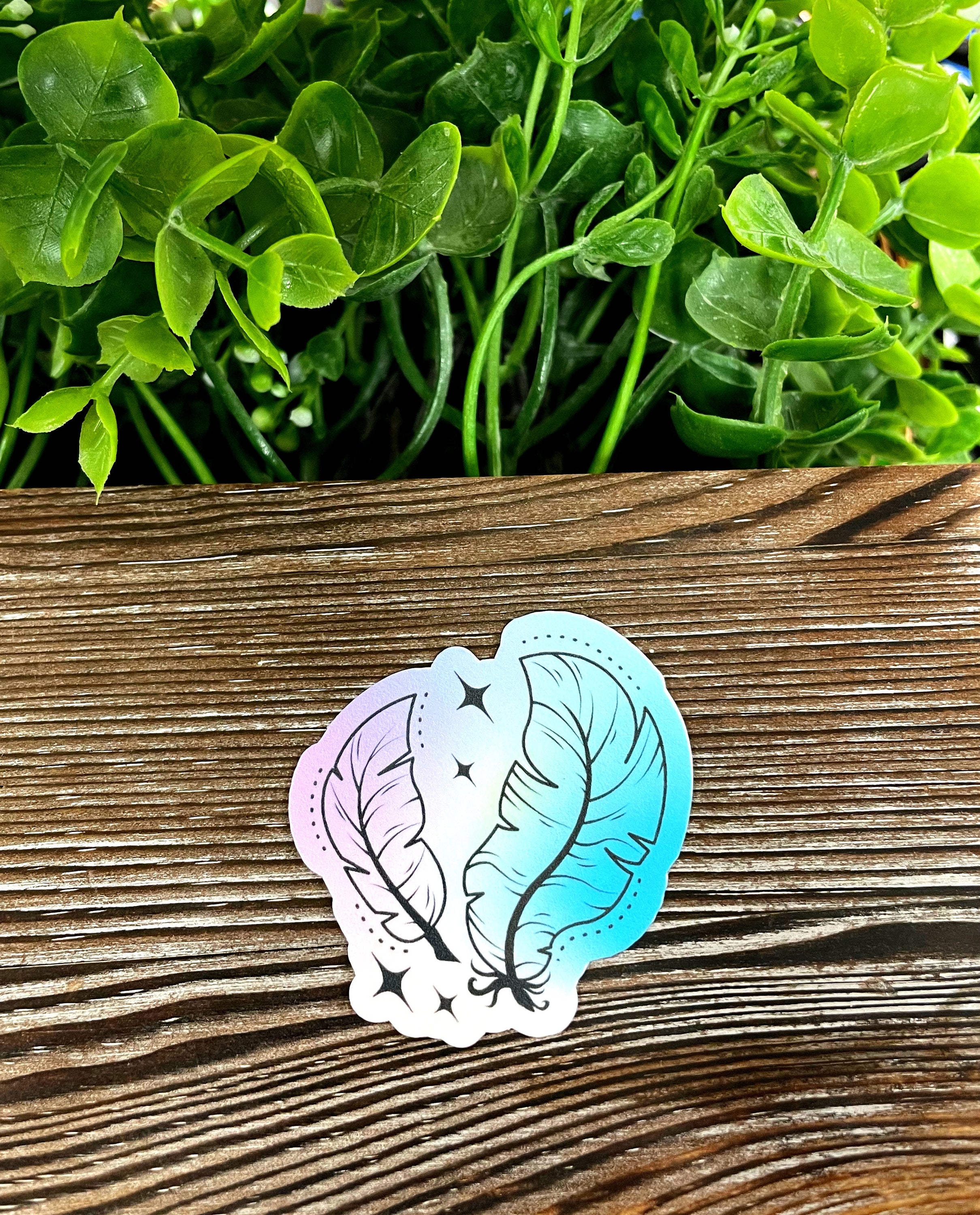 A vibrant watercolor feather die cut vinyl sticker showcasing boho design, perfect for personalizing various surfaces.